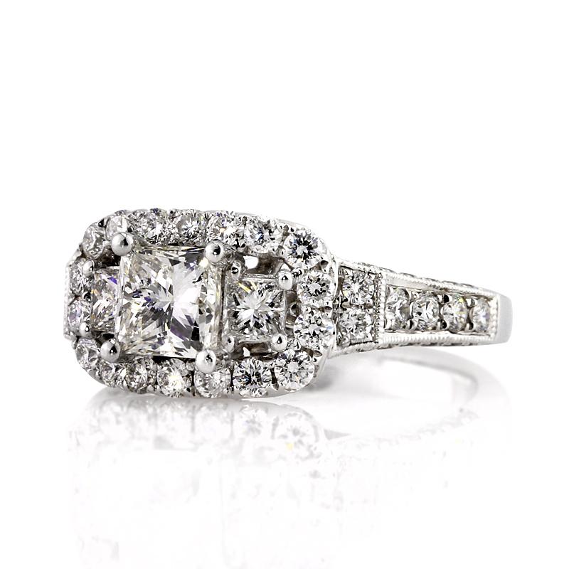 This gorgeous diamond engagement ring features a 1.04ct princess cut diamond at the center, EGL certified at E-VS1. It is flanked by two smaller princess cut diamonds on either side and accented by a matching halo of round brilliant cut diamonds.