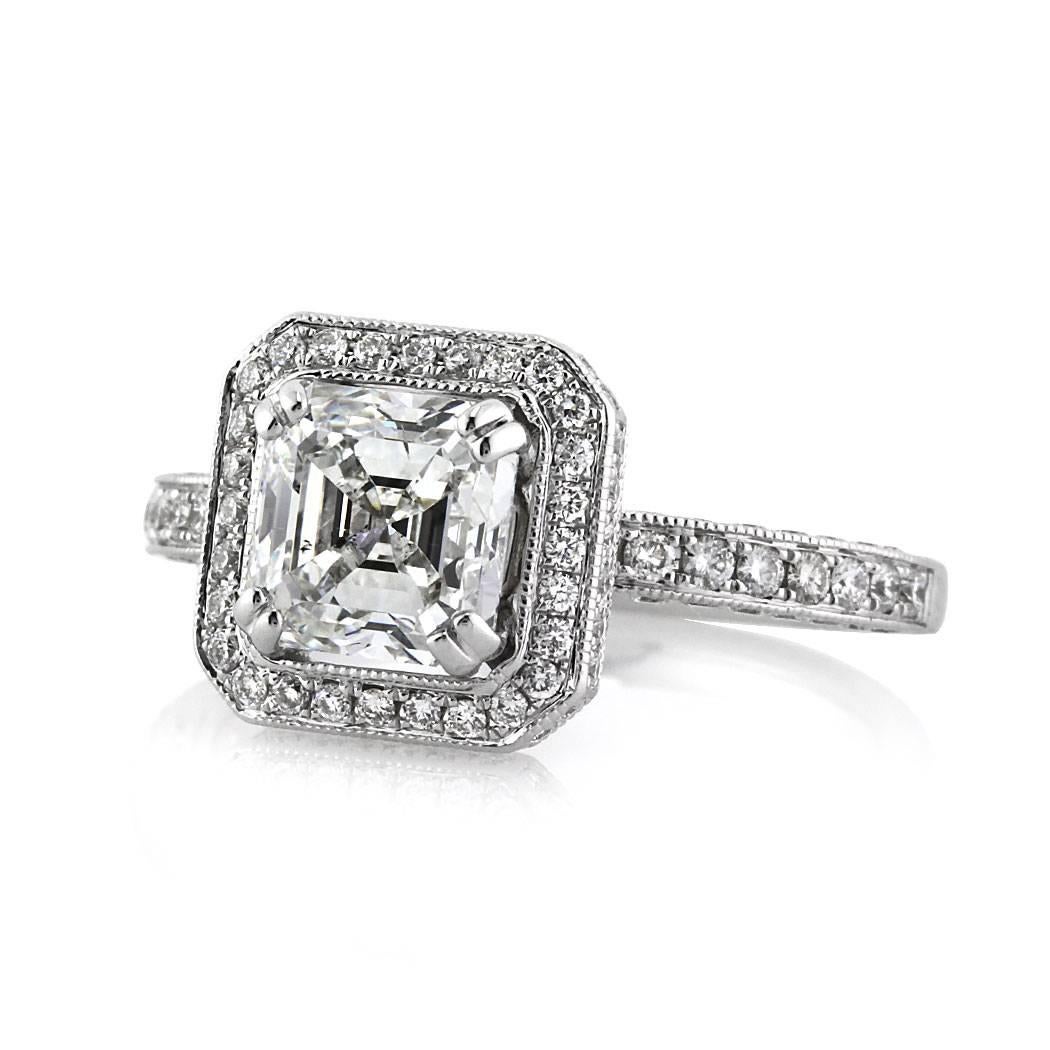 This gorgeous diamond engagement ring features a stunning 1.80ct Asscher cut center diamond, GIA certified at F-SI1. It is accented by a shimmering halo of round brilliant cut diamonds as well as one row of diamonds pavé set on all three sides of