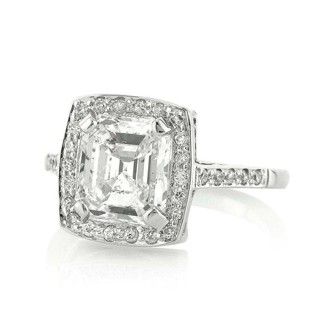 This beautiful diamond engagement ring is set with a stunning 2.28ct Asscher cut center diamond EGL certified at G, SI2. It is encased in a halo of round brilliant cut diamonds with sparkling diamonds going down the dainty shank in this 18k white