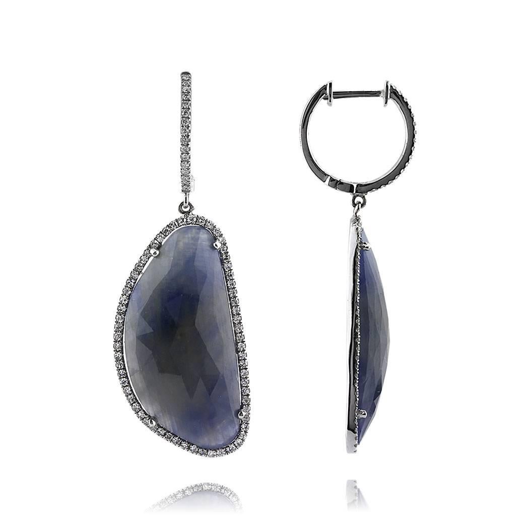 Custom created in 14k white gold, this elegant pair of dangle earrings features 27.68ct of rose cut sapphires complimented with a halo of single cut diamonds. The accent diamonds are graded at G-H, VS2-SI1.