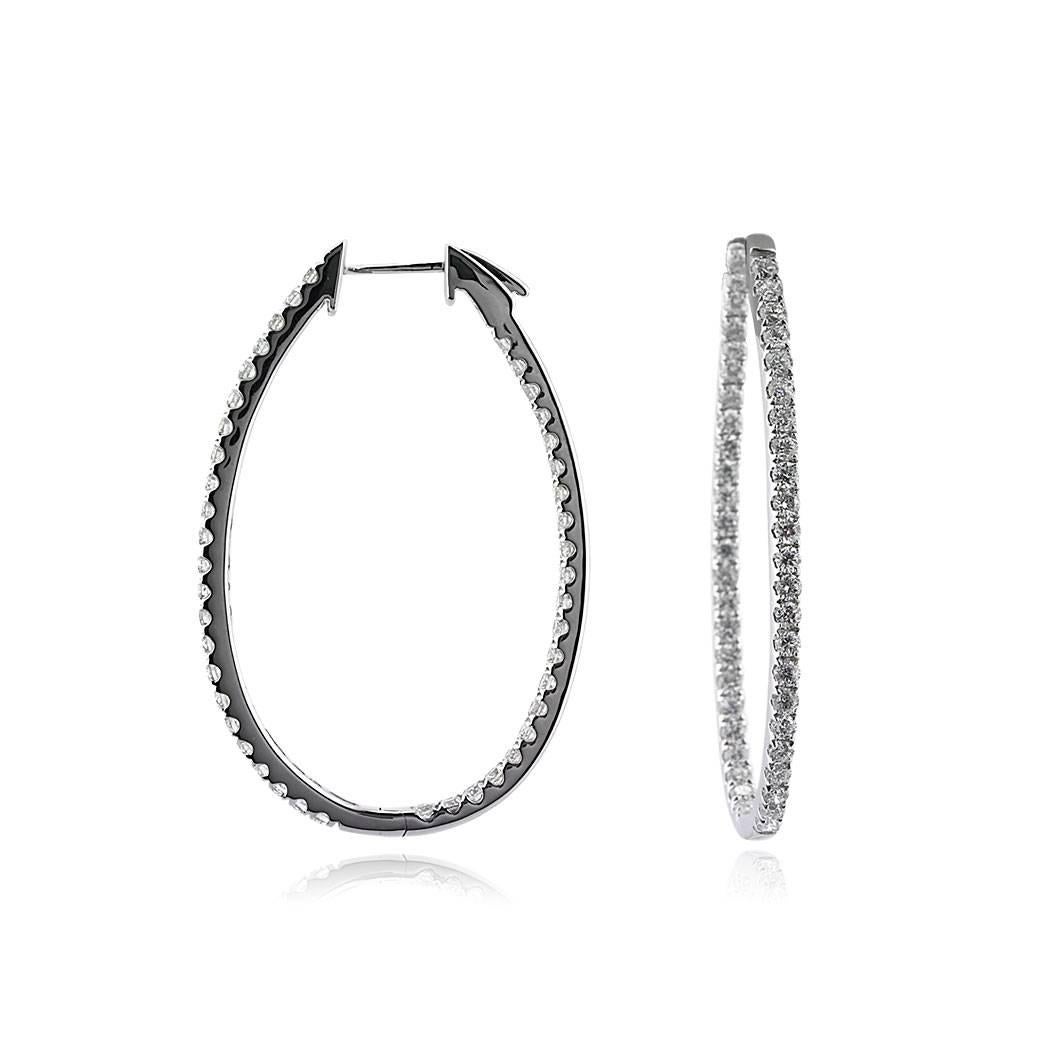 Handcrafted in 18k white gold, this stunning pair of elongated diamond hoop earrings showcases 2.95ct of round brilliant cut diamonds graded at E-F, VS2-SI1. For minimal metal showing, the diamonds are set from front to back.