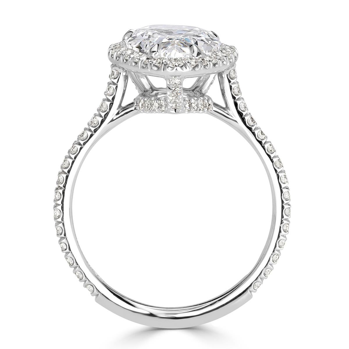 This mesmerizing beauty showcases an exceptional 2.46ct pear shaped center diamond, GIA certified at E-SI2. It faces up peerless white and completely eye-clean with minimal white inclusions. It is accented by a halo of round brilliant cut diamonds
