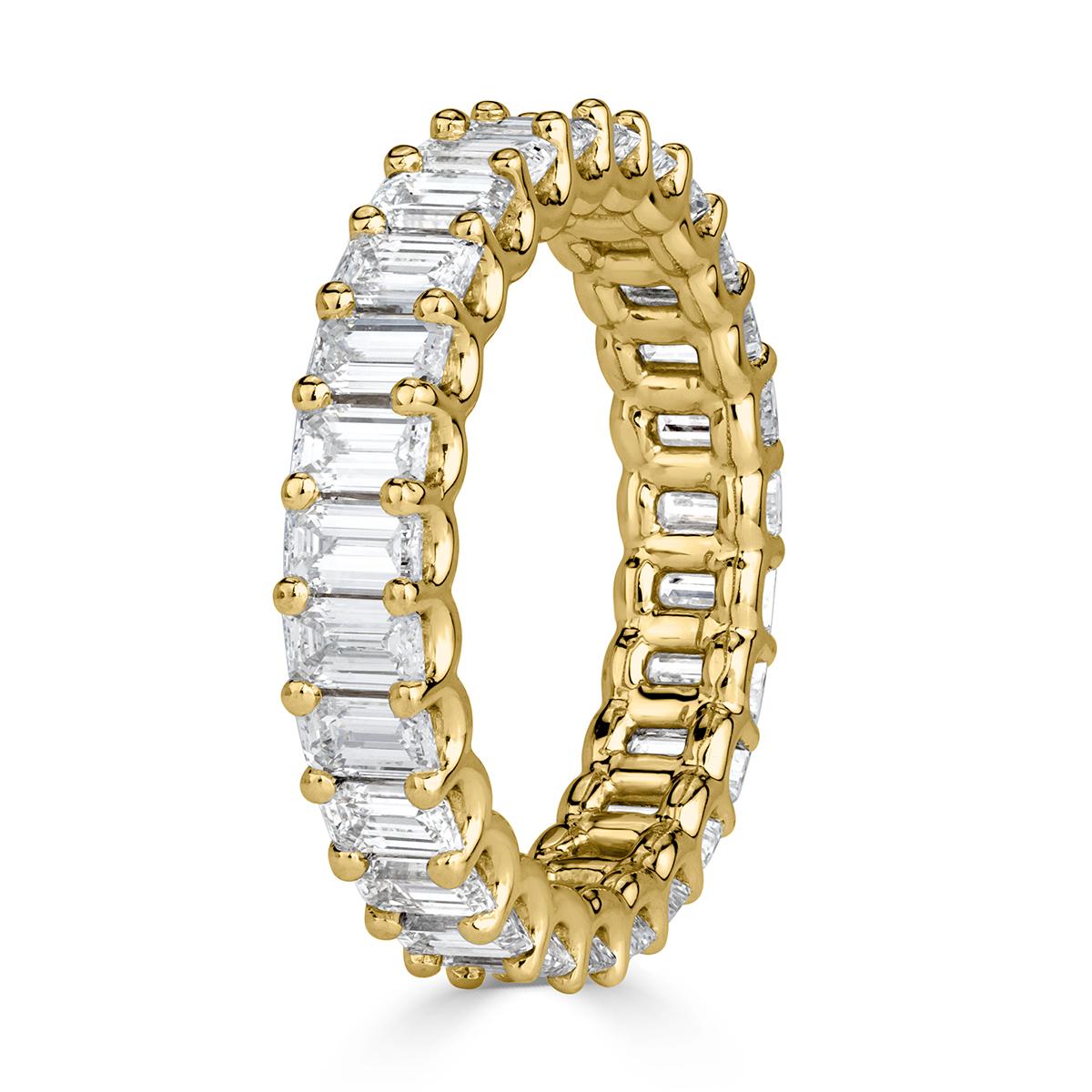 This stunning diamond eternity band features 3.15ct of emerald cut diamonds graded at E-F in color, VVS2-VS1 in clarity. They are set in a custom, 18k yellow gold 
