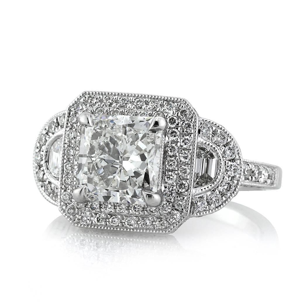 This mesmerizing piece features a gorgeous 2.03ct radiant cut center diamond, GIA certified at H-SI1. It is accented by a double halo of round brilliant cut diamonds in a pave setting style and two step cut half moon on either sides. For maximum