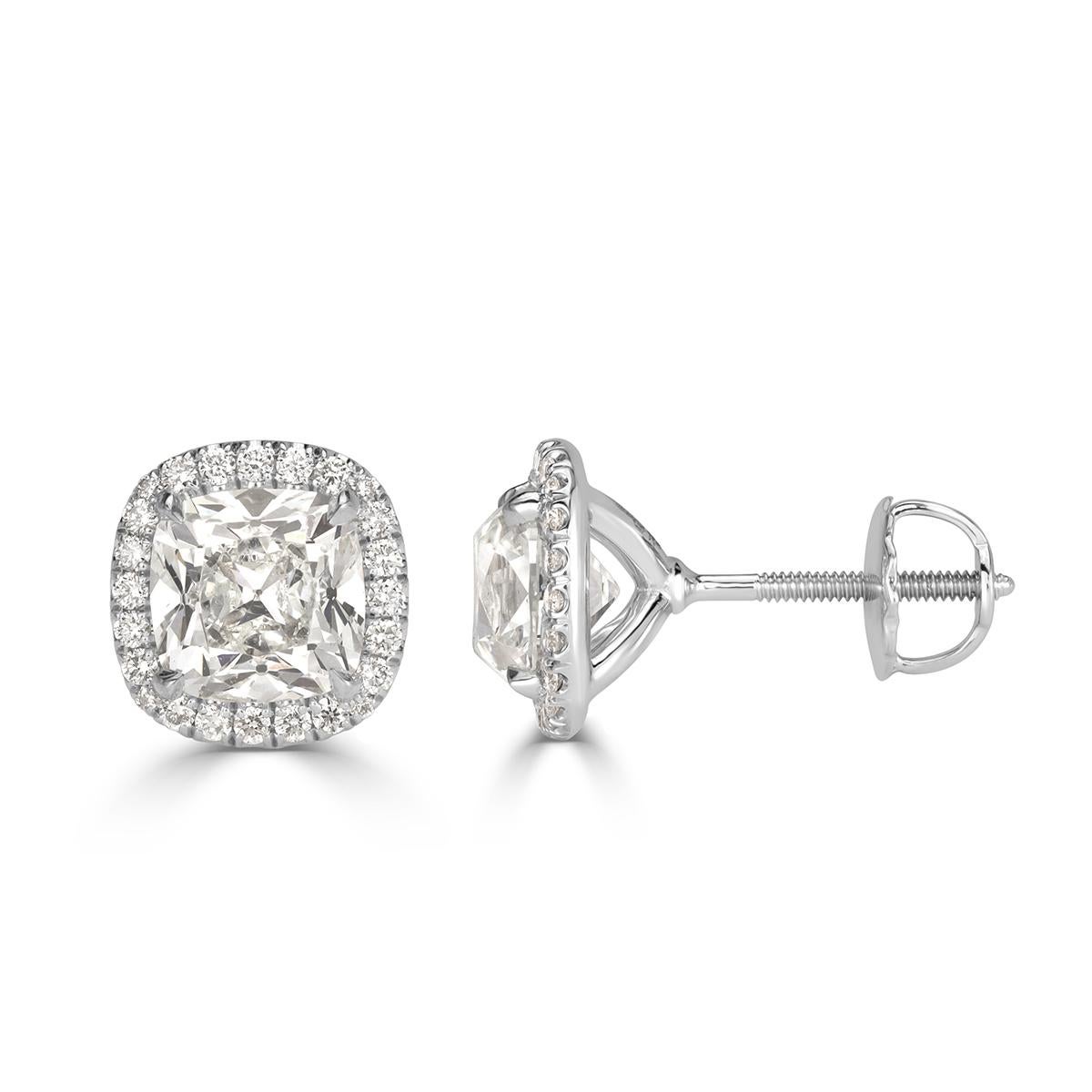 This gorgeous pair of diamond stud earrings showcases two old Mine cut center diamonds with a respective weight of 1.50ct each. They are both GIA certified at F in color, SI1- SI2 in clarity and accented by a shimmering halo of smaller round