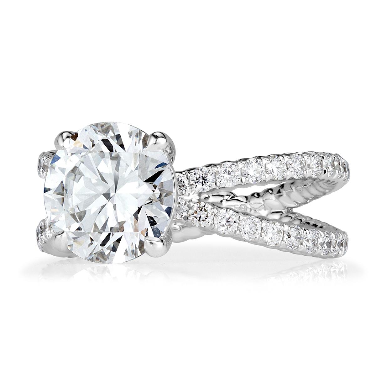 This stunning diamond engagement ring showcases a mesmerizing 2.75ct round brilliant cut center diamond, GIA certified at H in color, VS2 in clarity. It is poised atop a unique 18k white gold shank micro pavé set with 0.80ct of smaller round