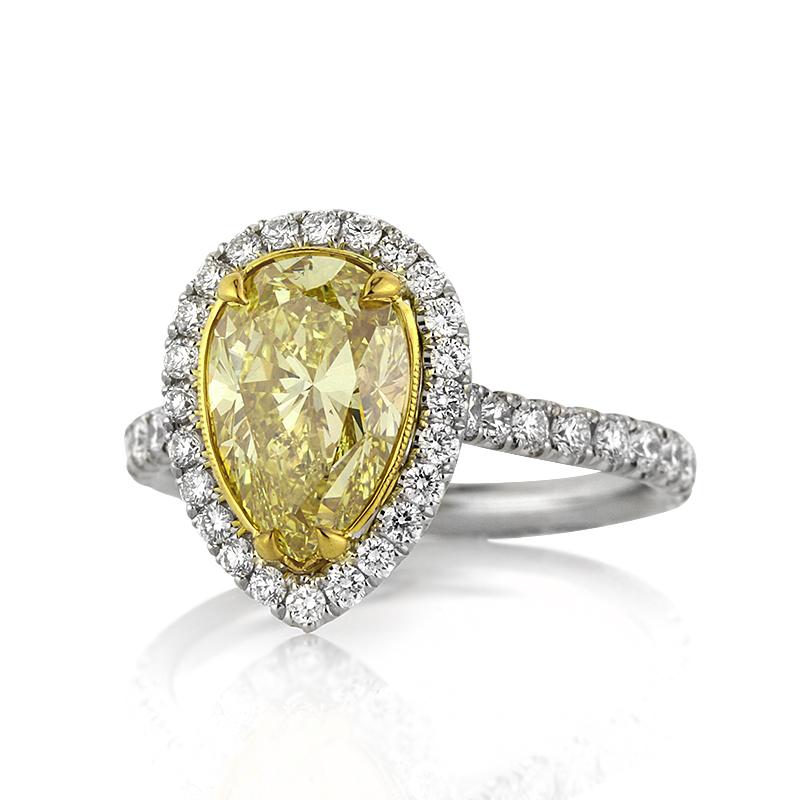 This captivating diamond engagement ring showcases a mesmerizing 2.50ct pear shaped center diamond, GIA certified at Fancy Intense Yellow- SI1. It is accented by a halo of white round brilliant cut diamonds as well as dazzling diamonds adorning the