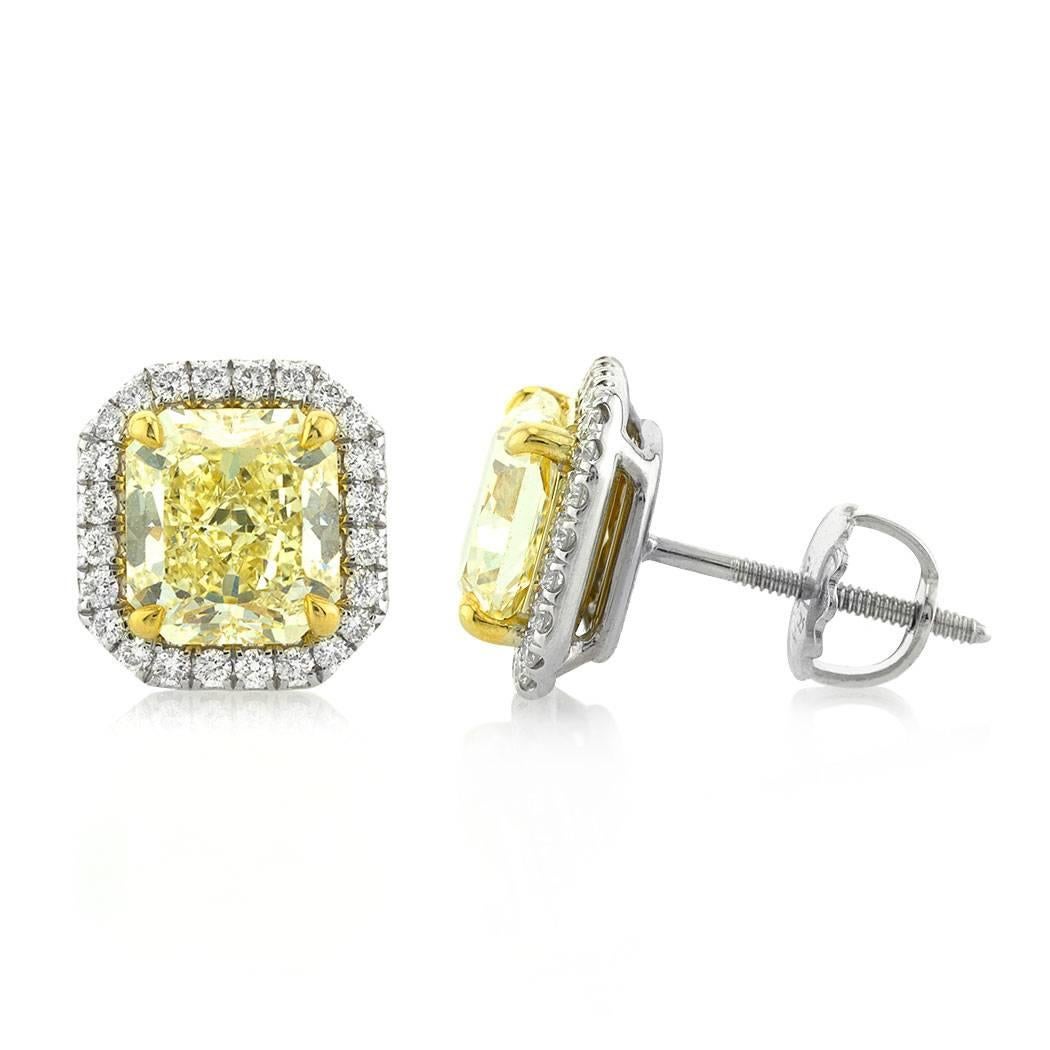 These captivating pair of diamond earrings is set with two gorgeous radiant cut diamonds weighing respectively 1.72ct and 1.74ct. They are each GIA certified at Fancy Yellow-VVS1 and VS1 and surrounded by shimmering halos of peerless white round