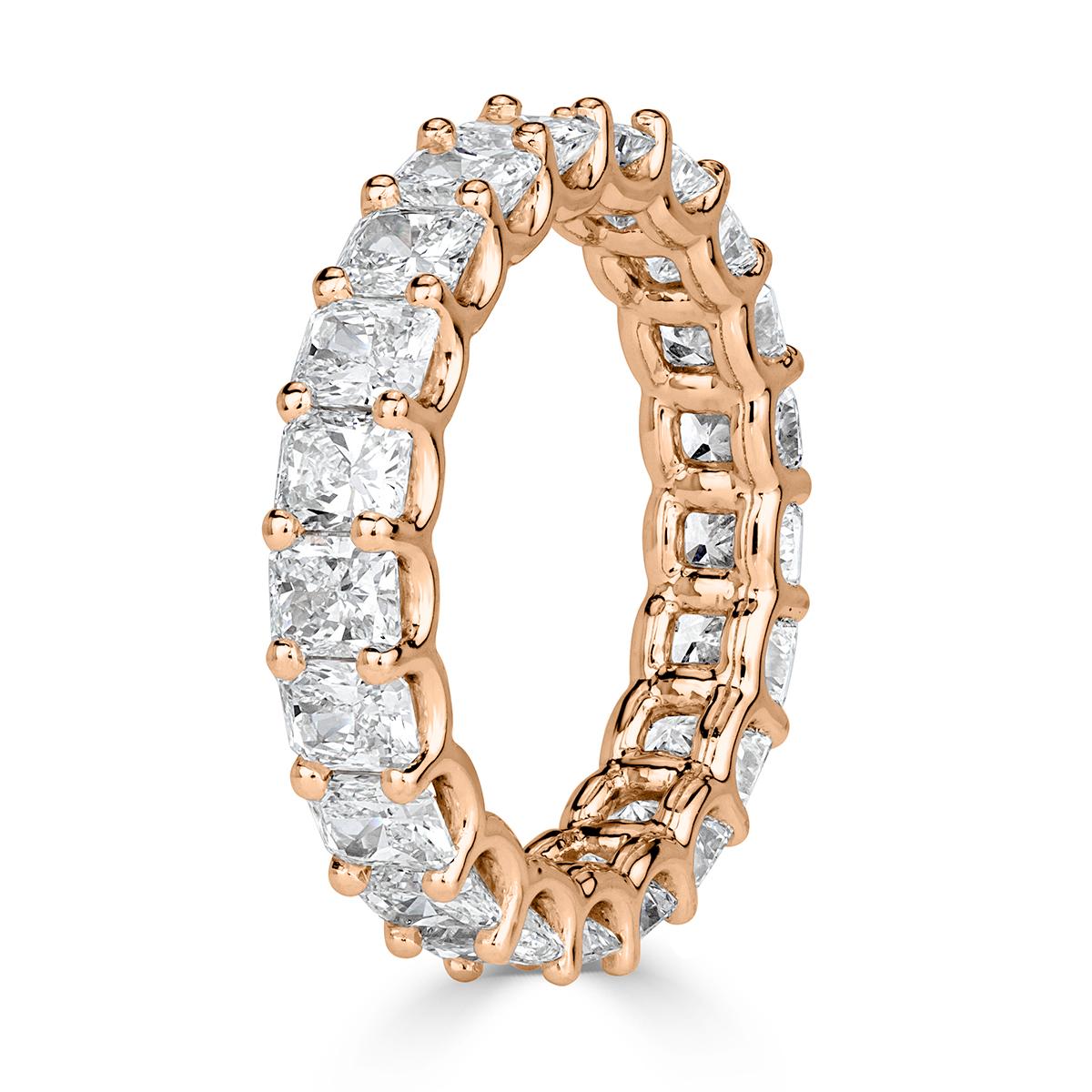 Custom created in 18k rose gold, this stunning diamond eternity band showcases 4.14ct of radiant cut diamonds graded at E-F, VS1-VS2. They are set in a 