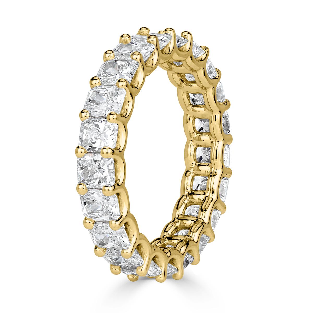 Custom created in 18k yellow gold, this stunning diamond eternity band showacses 4.14ct of radiant cut diamonds graded at E-F, VS1-VS2. They are set in a 