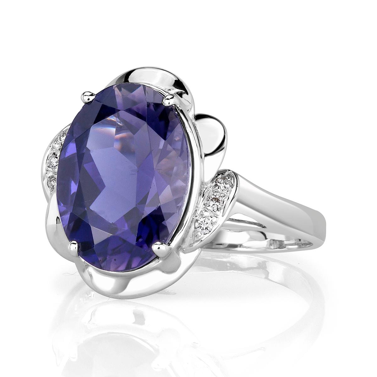 Designed in 18k white gold, this beautiful ring features a 4.81ct, GIA certified oval cut center Iolite. It is beautifully showcased in a floral center basket sprinkled with 0.06ct of shimmering round brilliant cut diamonds.