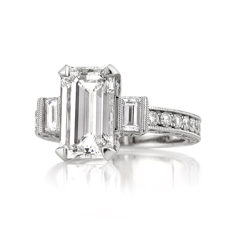 This superb diamond engagement ring showcases a stunning 3.29ct emerald cut center diamond, GIA certified at G-VS1. It is accented by two baguette cut diamonds on either side as well as sparkling round brilliant cut diamonds studded on the center