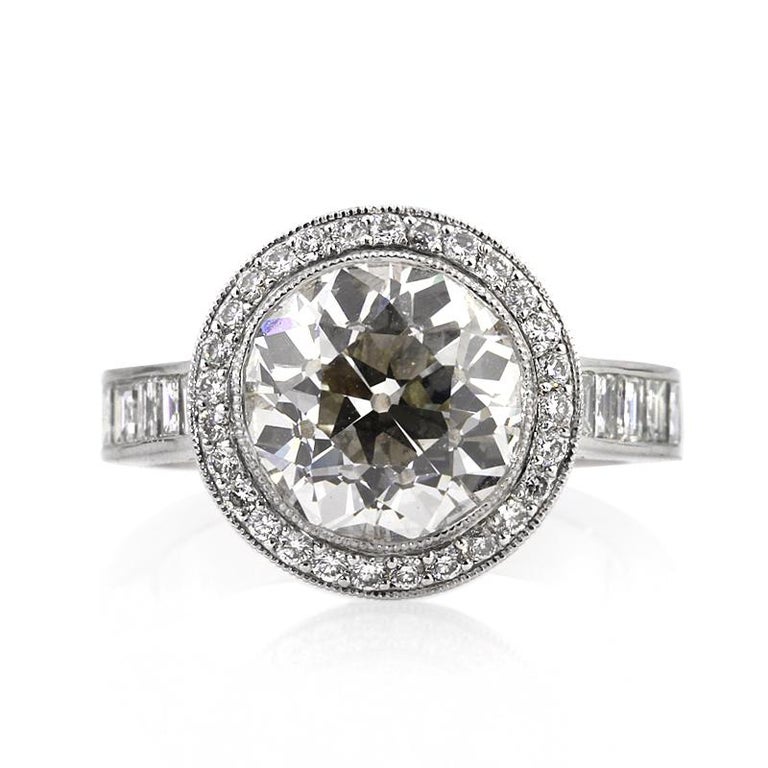 This stunning diamond engagement ring features a superb 3.84ct old European cut center diamond, AGS certified at I-VS1. It is beautifully showcased in a unique platinum setting adorned with 3.25ct of round and carré cut diamonds. All of the accent