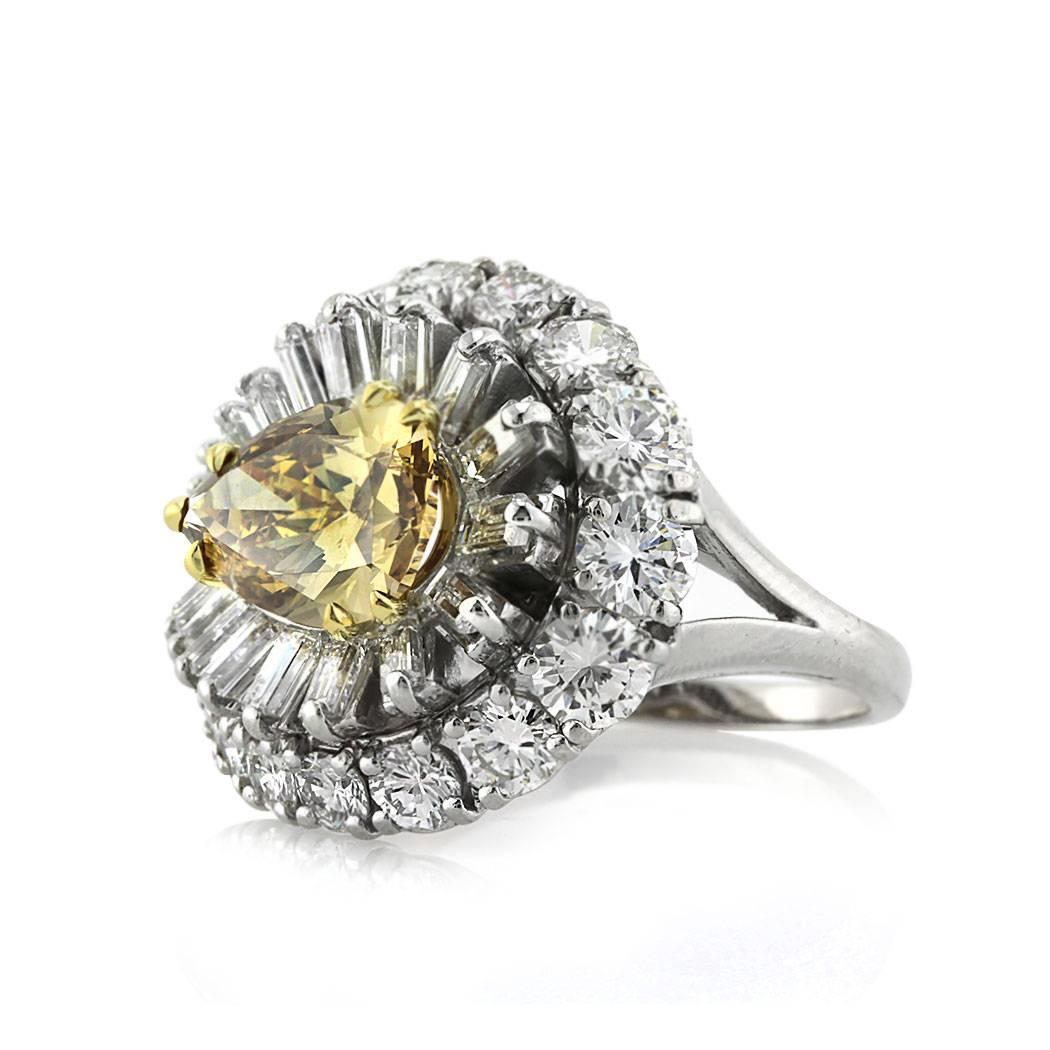 This very unique diamond engagement ring is set with a beautiful 2.36ct pear shaped center diamond, GIA certified at Fancy Dark Brown Yellow-I1. It is complimented by a two sided halo of seamlessly matched baguette and round brilliant cut diamonds