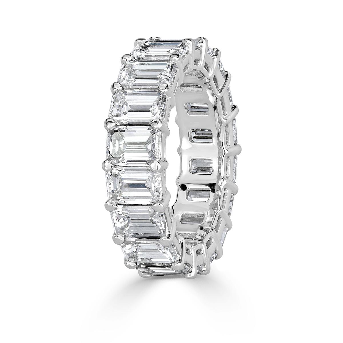 Custom created in platinum, this statement diamond eternity band showcases 9.09ct of emerald cut diamonds graded at E-F, VVS1-VVS2. The diamonds are each hand selected and set in a classic basket setting. All eternity bands are shown in a size 6.5.