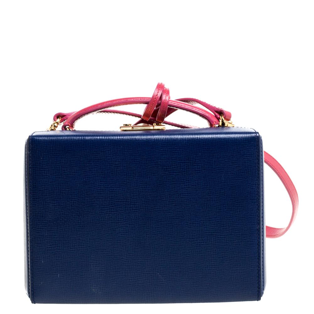 This creation is from the iconic collection of Mark Cross' Grace Box bags. It carries a combination of blue and pink hues and is crafted from leather. The bag comes with a top handle, a detachable leather strap, and top hardware closure with the