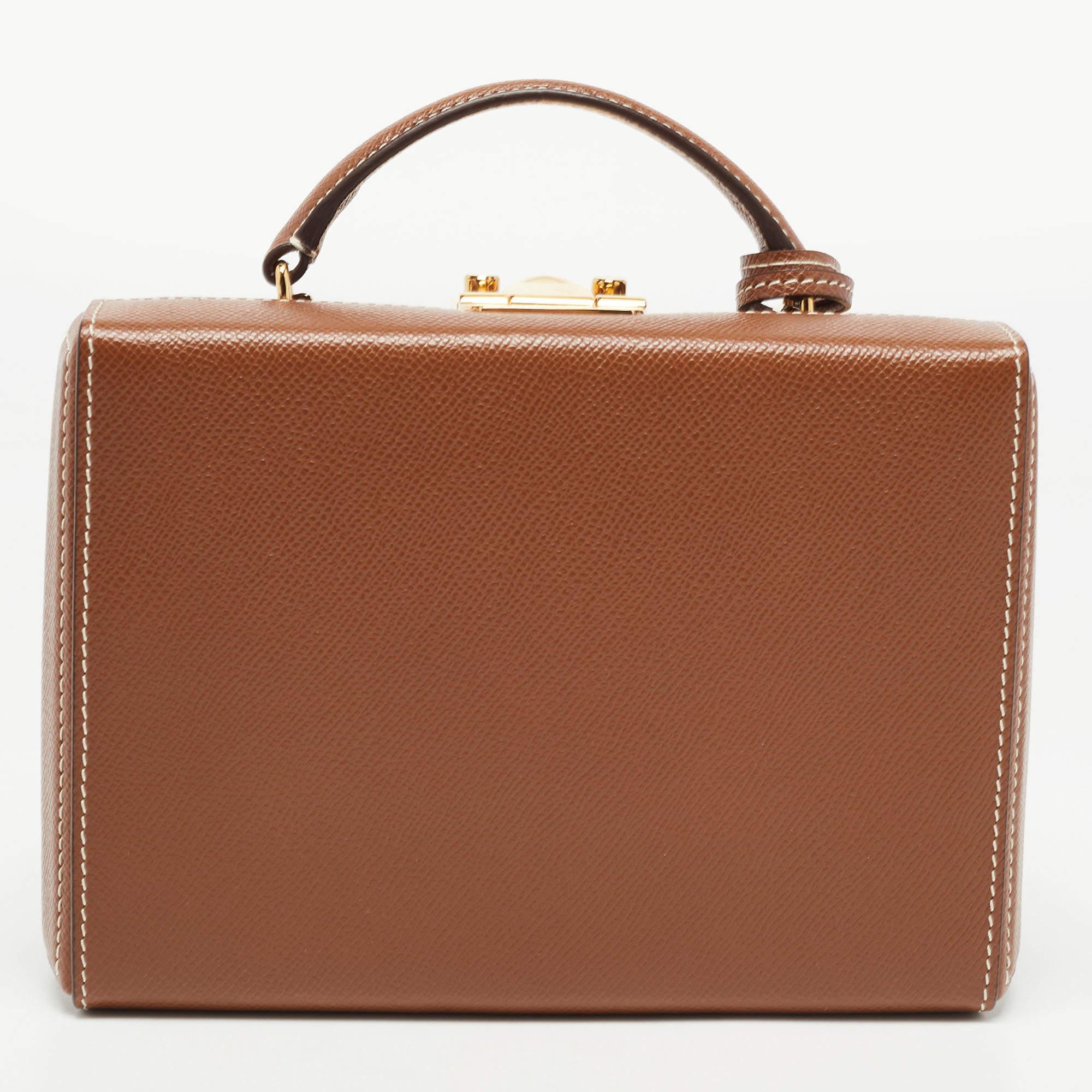This Mark Cross Grace Box bag showcases the label's classy design attributes. It is made from leather in a classy shade and added with a shapely top handle and a detachable strap.

Includes: Key, Detachable Strap
