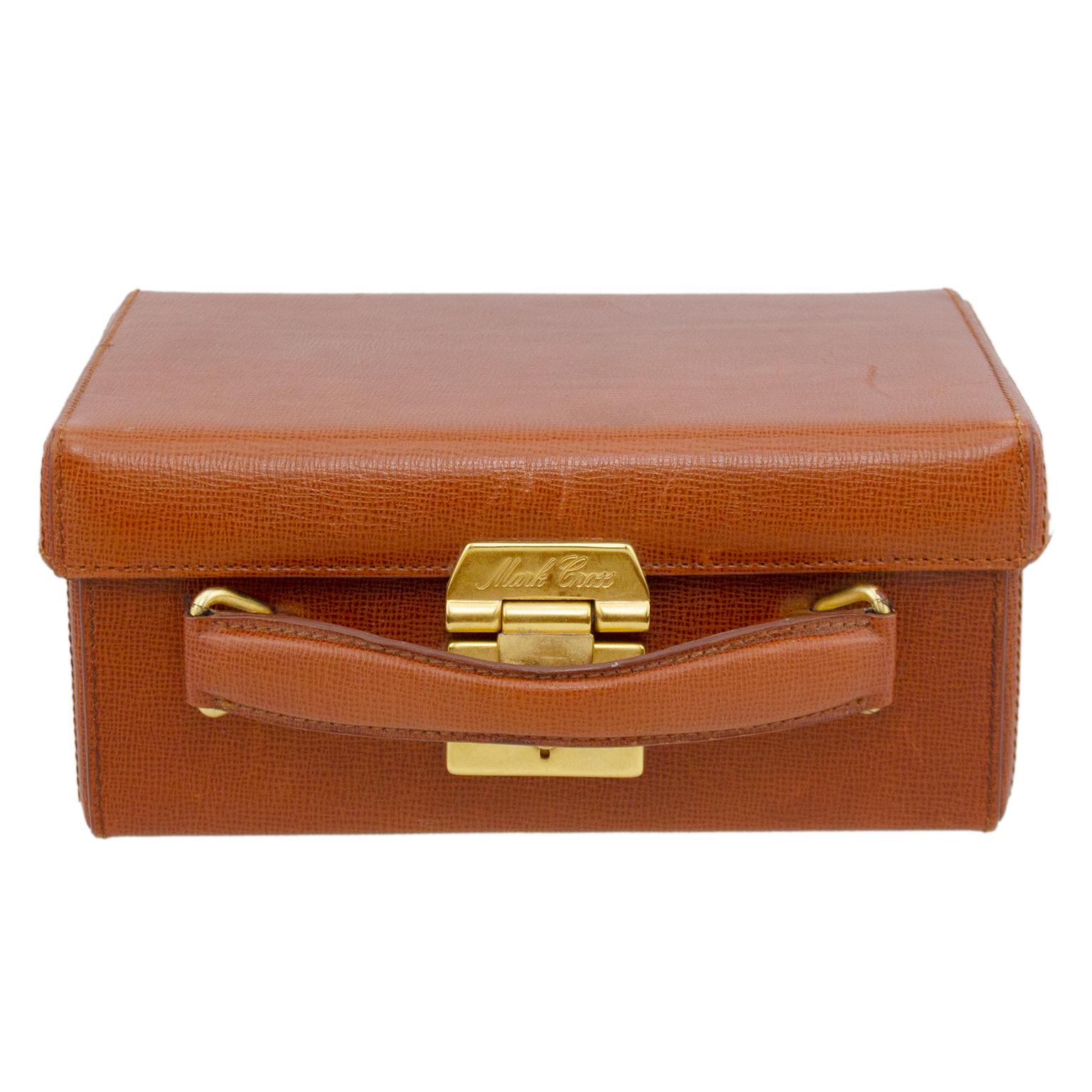 Always classic and timeless, the Mark Cross Grace box bag is named after Grace Kelly in 1954 film Rear Window. This box bag is chestnut brown rigid leather with gold tone hardware and a top handle. The bag opens to a tan leather interior with a