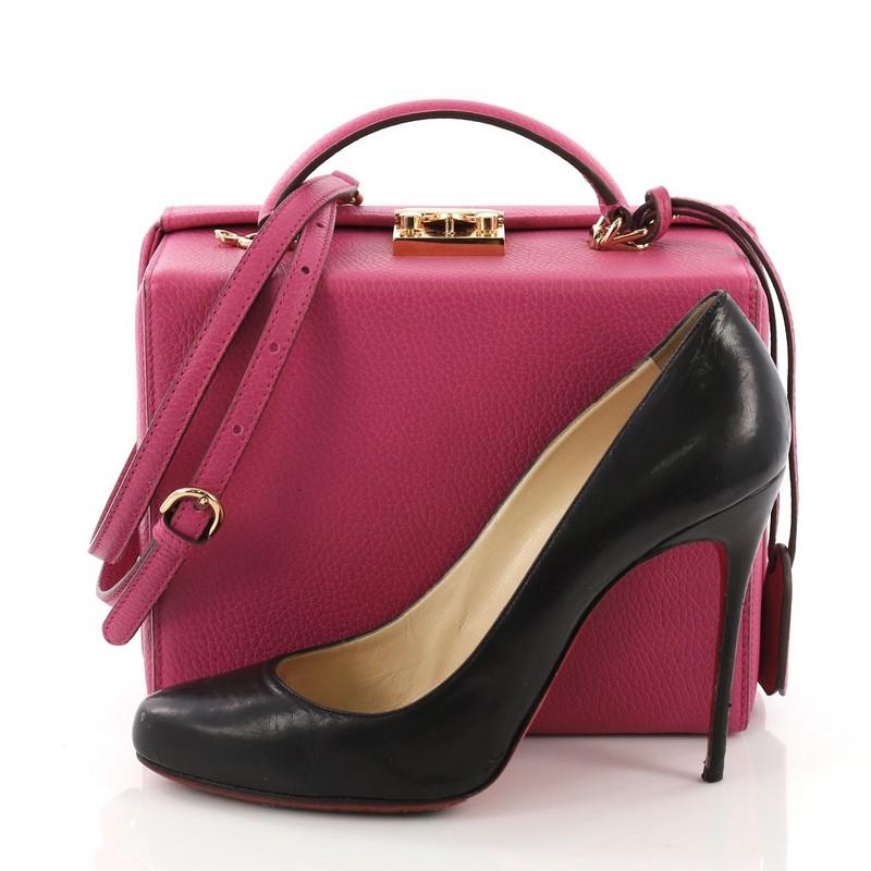 This Mark Cross Grace Box Bag Leather Large, crafted from pink leather, features a leather top handle, protective base studs, and gold-tone hardware. Its push-lock closure opens to a red leather interior with zip pocket. **Note: Shoe photographed is