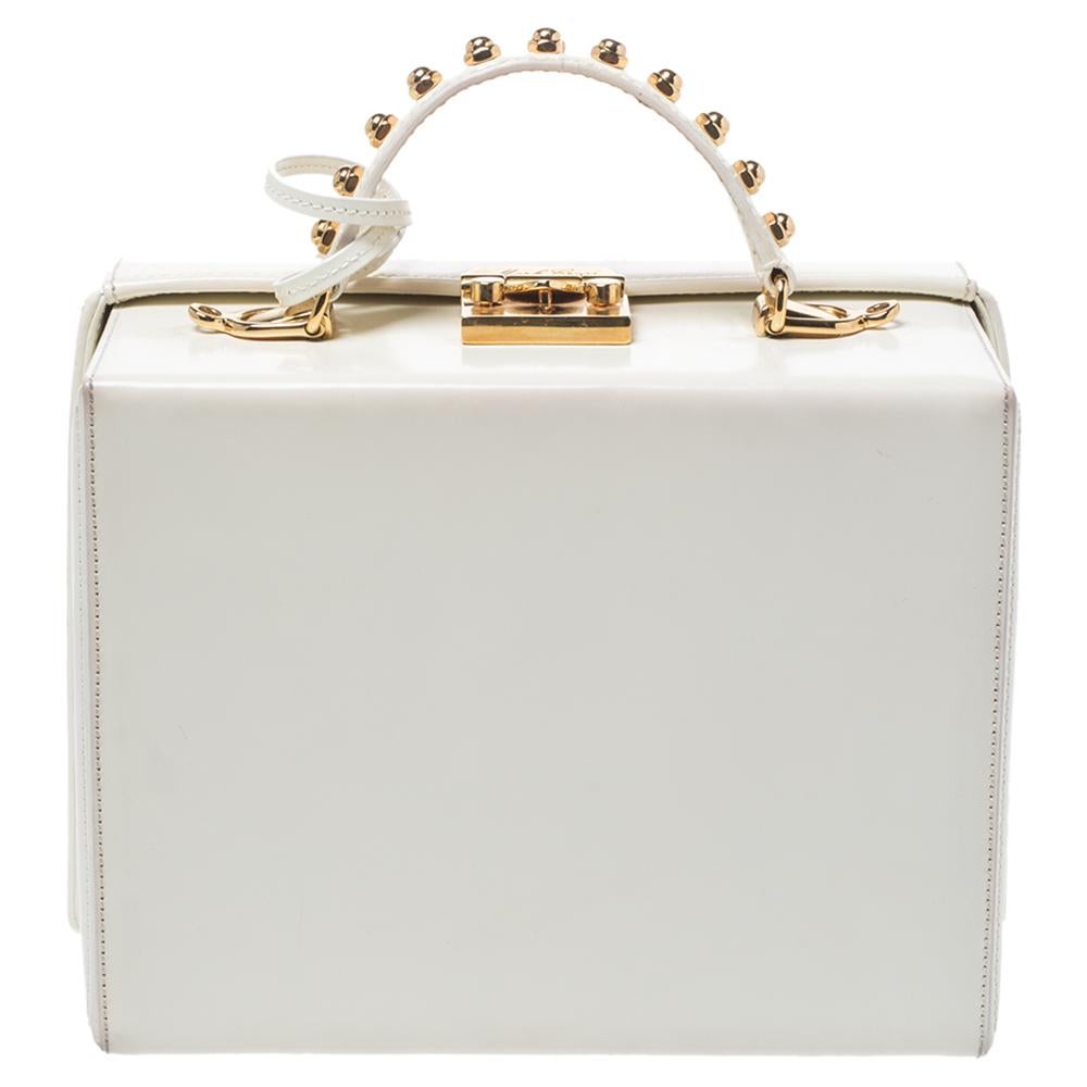 This creation is from the iconic collection of Mark Cross' Grace Box bags. It carries the ageless combination of white leather and carefully placed gold-tone studs. The bag comes with a top handle, a detachable leather strap and top hardware closure