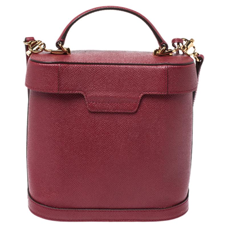 This Mark Cross bag is the epitome of fun and feminine style. This multipurpose leather bag would go perfectly for any occasion. It has a structured shape with a top that resembles a lid. The bag is held by a top handle and a shoulder