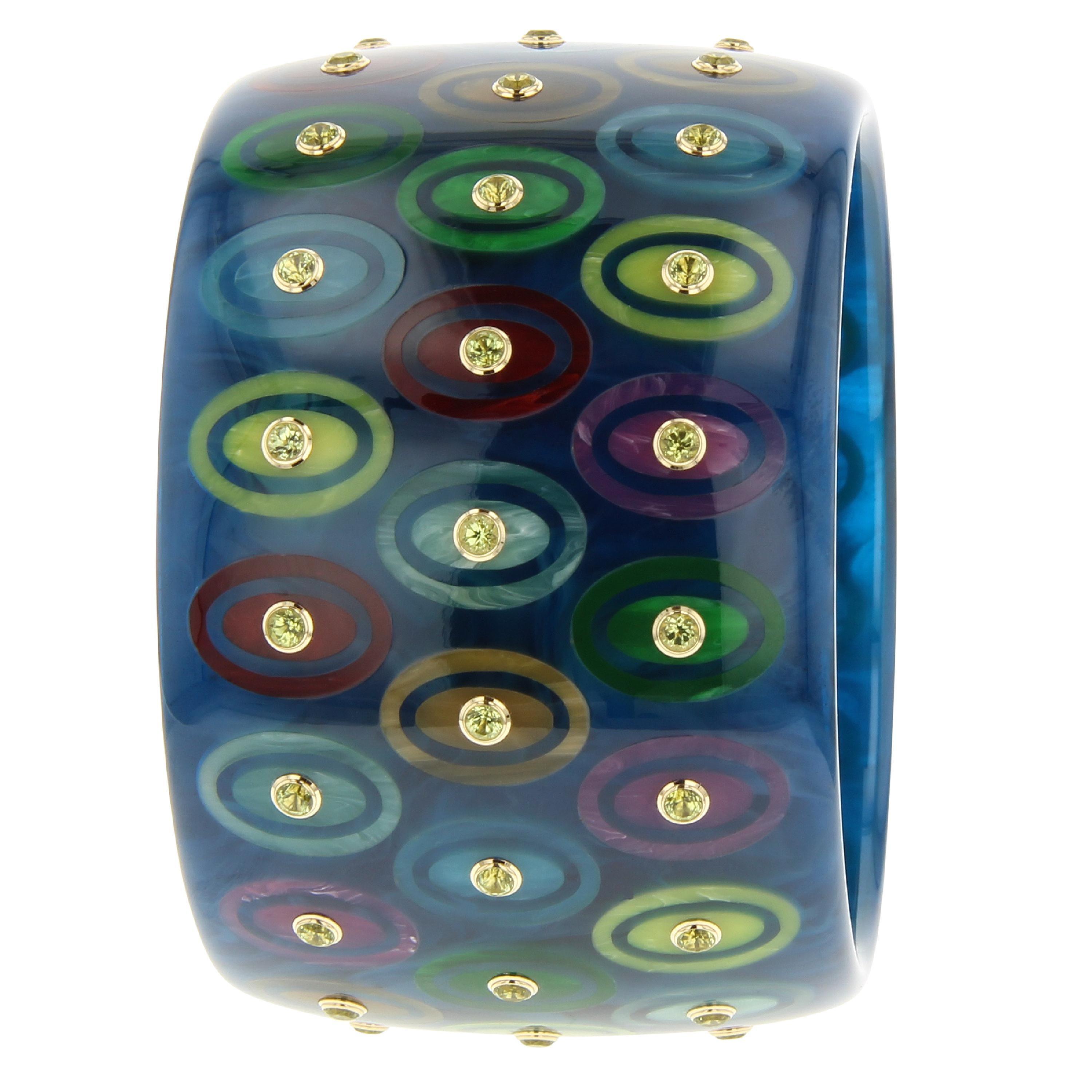 This unique and beautiful Mark Davis bangle was created from vintage, navy blue bakelite that has been expertly inlaid with ovals of various colored vintage bakelite. The ovals sections are further surrounded by an oval frame in the same color