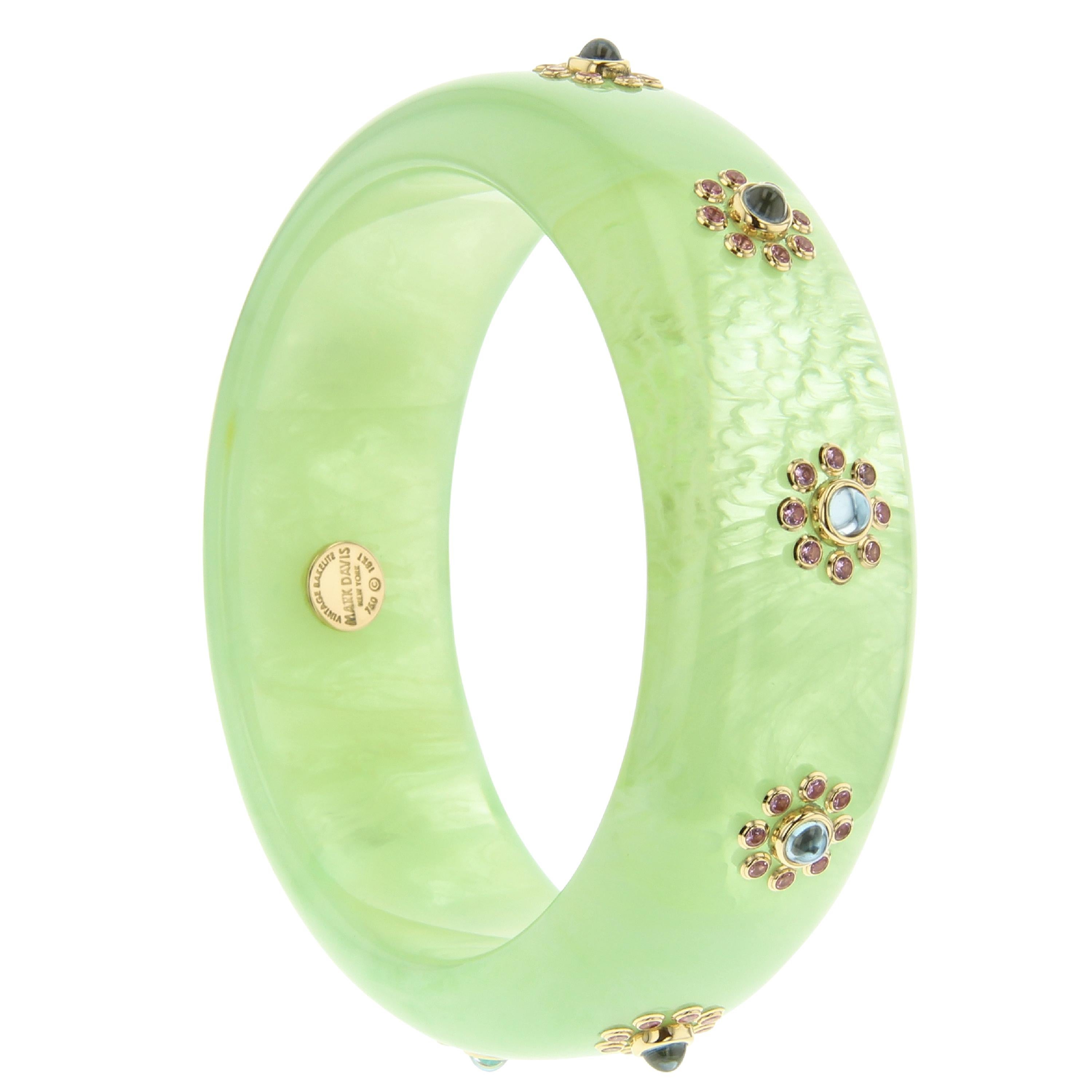 This Mark Davis bangle was created with an almost ethereal green vintage bakelite. The bakelite has marbling throughout that is reminiscent of fluffy clouds floating in the sky. Blue topaz cabochons are set in 18k yellow gold bezels and are