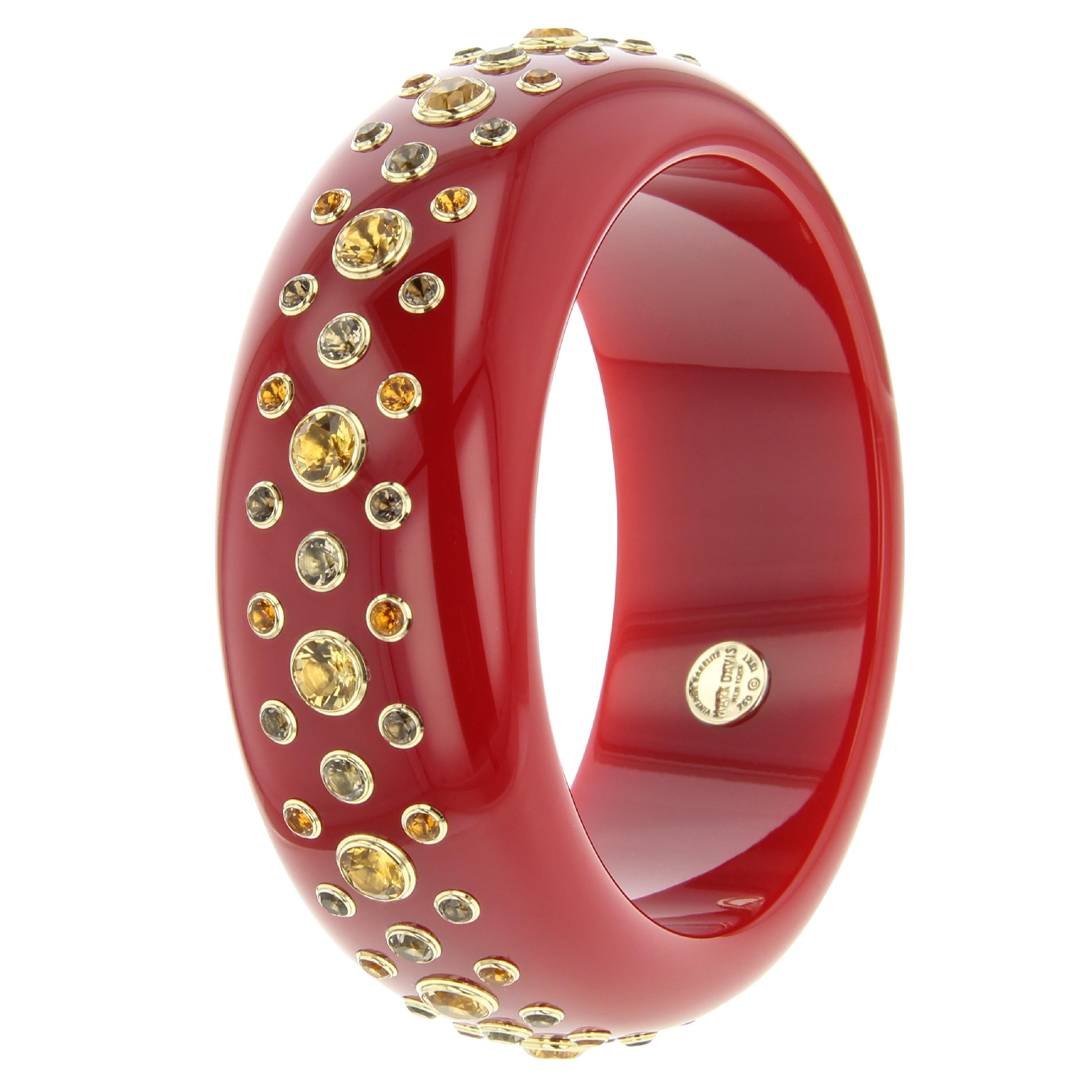 This bold, deep red, vintage bakelite bangle by Mark Davis makes a strong statement. The bakelite is not marbled which makes the red color even more intense. The bracelet features two distinct shades of citrine along with smoky quartz. The stones