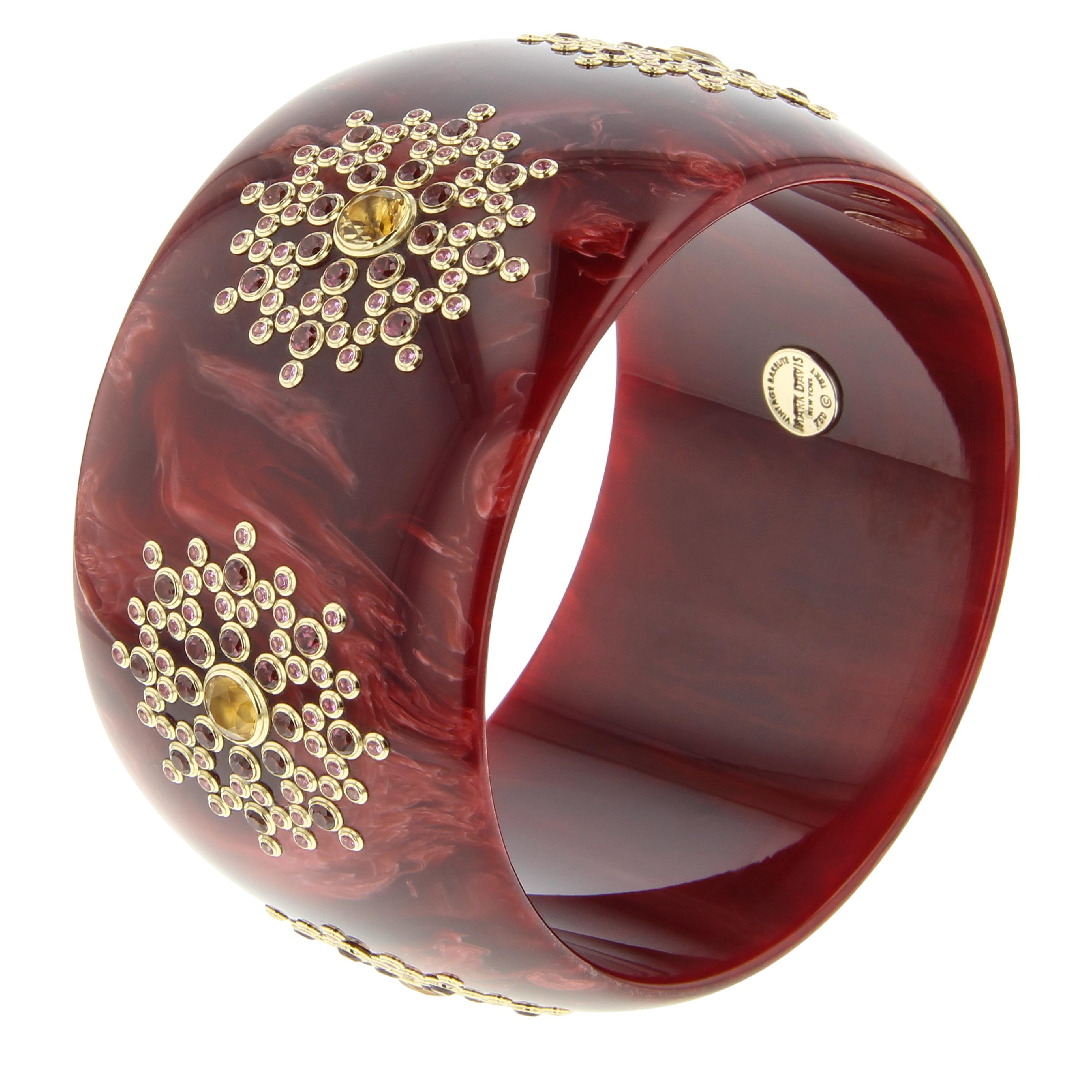 This elegant bangle was created with a rich, vintage, burgundy bakelite that has been set with fine gemstones in a complex and super-precise geometric pattern. The color of the bakelite and gemstones makes this bangle ideal for year-round wear.