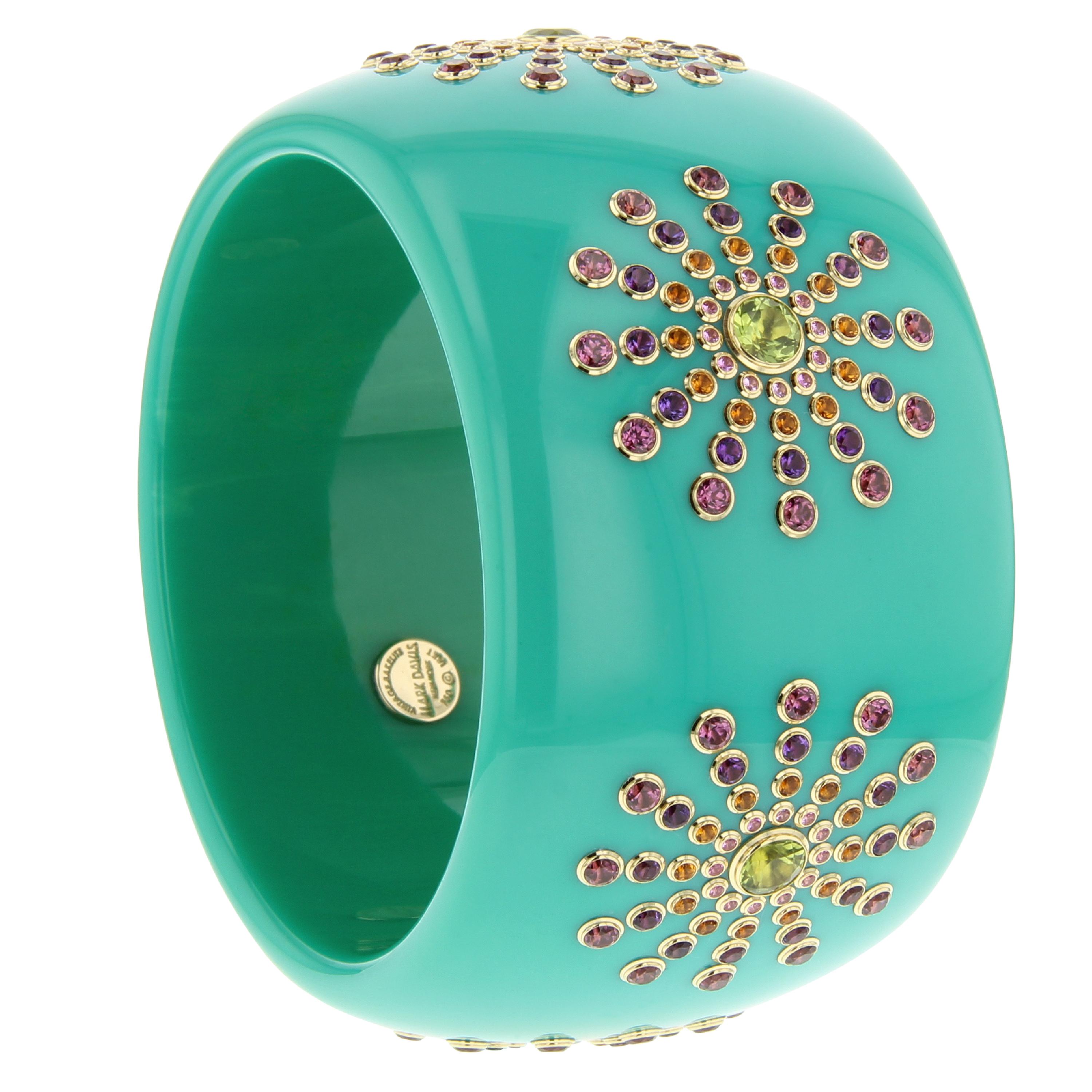 This substantial Mark Davis bangle was made from vintage turquoise bakelite. The bakelite is not marbled and the focus is entirely on the starburst pattern that repeats six times around the bracelet. The center of each starburst features a large