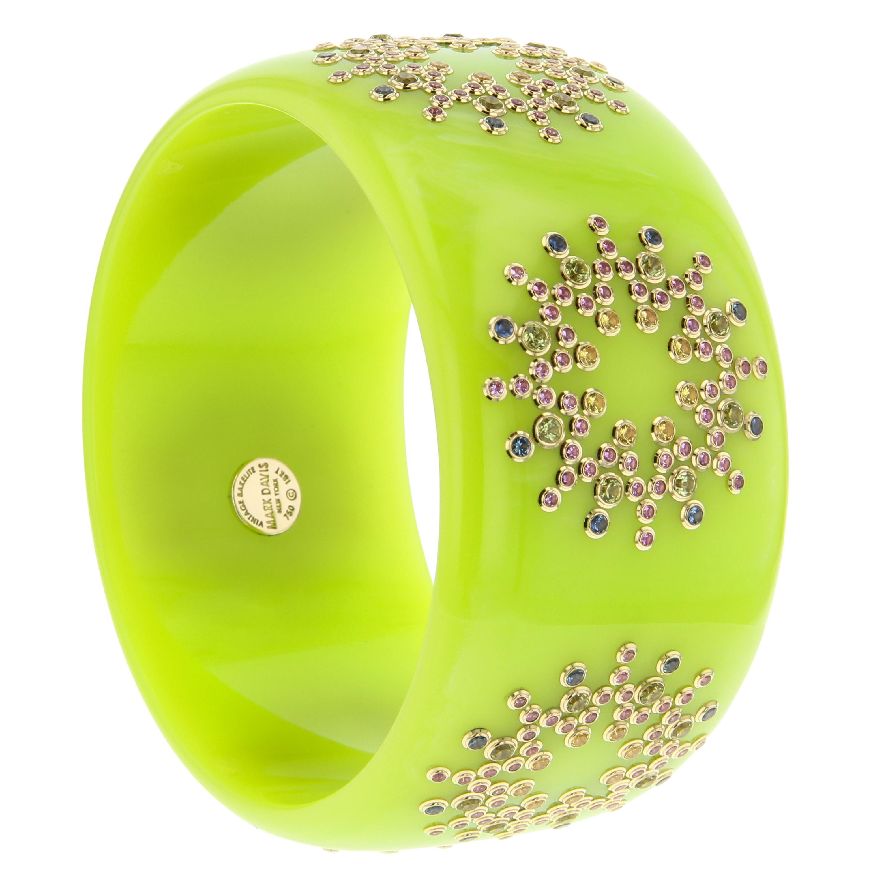 This bright and cheerful Mark Davis bangle made of vintage bakelite is a wonderful chartreuse color with extremely subtle marbling. Six stations around the bangle are precisely set with fine sapphires in blue, pink and yellow as well as peridot. The