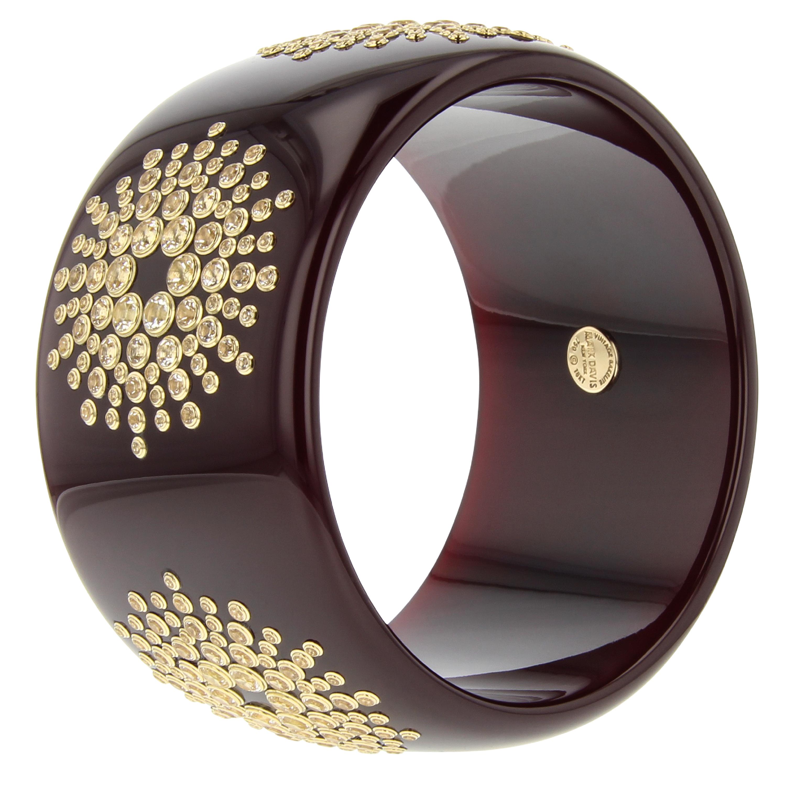 This head-turning Mark Davis bangle was made by hand using a very deep purple, unmarbled, vintage bakelite. A brilliant starburst pattern has been precisely applied to the bangle. Every stone in the pattern has been individually set in 18k yellow