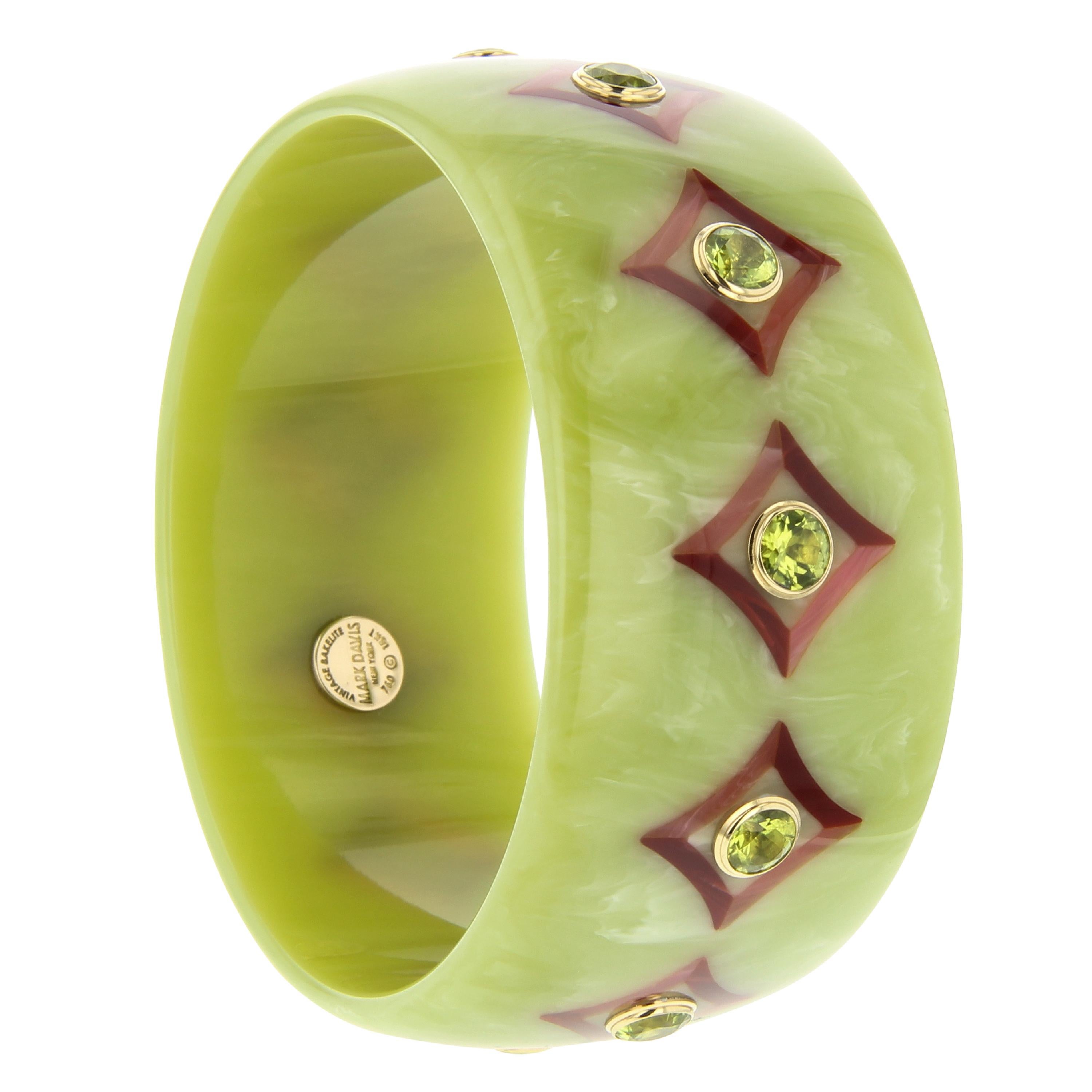 A gorgeous Mark Davis bangle. Made with a beautiful, soft green, vintage bakelite. The bracelet has been inlaid with a diamond or lozenge pattern featuring slightly indented sides. Burgundy and pink bakelite were used for the precise inlay. The