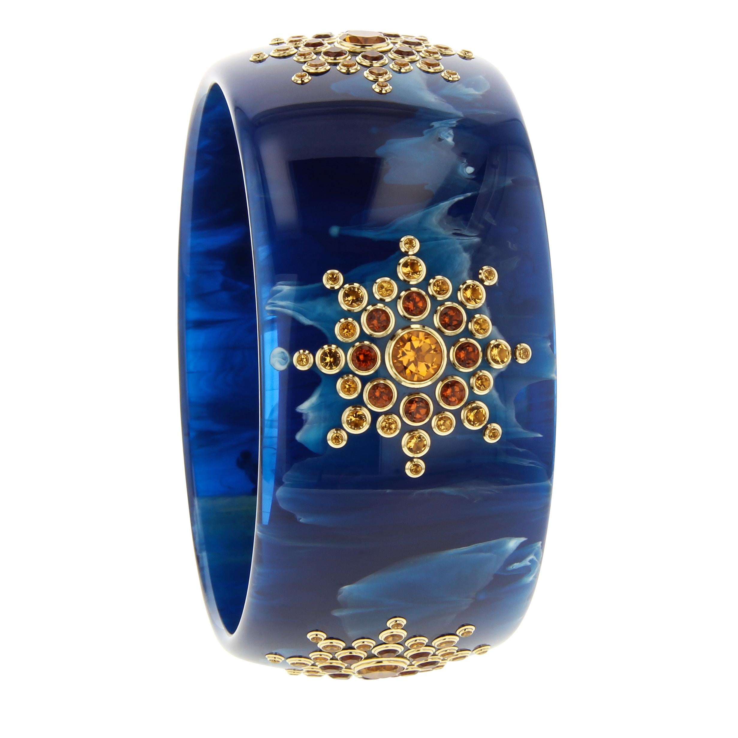 This gorgeously marbled blue vintage bakelite bangle has been set with five starbursts comprised of fine citrine in various shades. Although the shades of the citrine vary, they are perfectly matched in color and location at every station. In