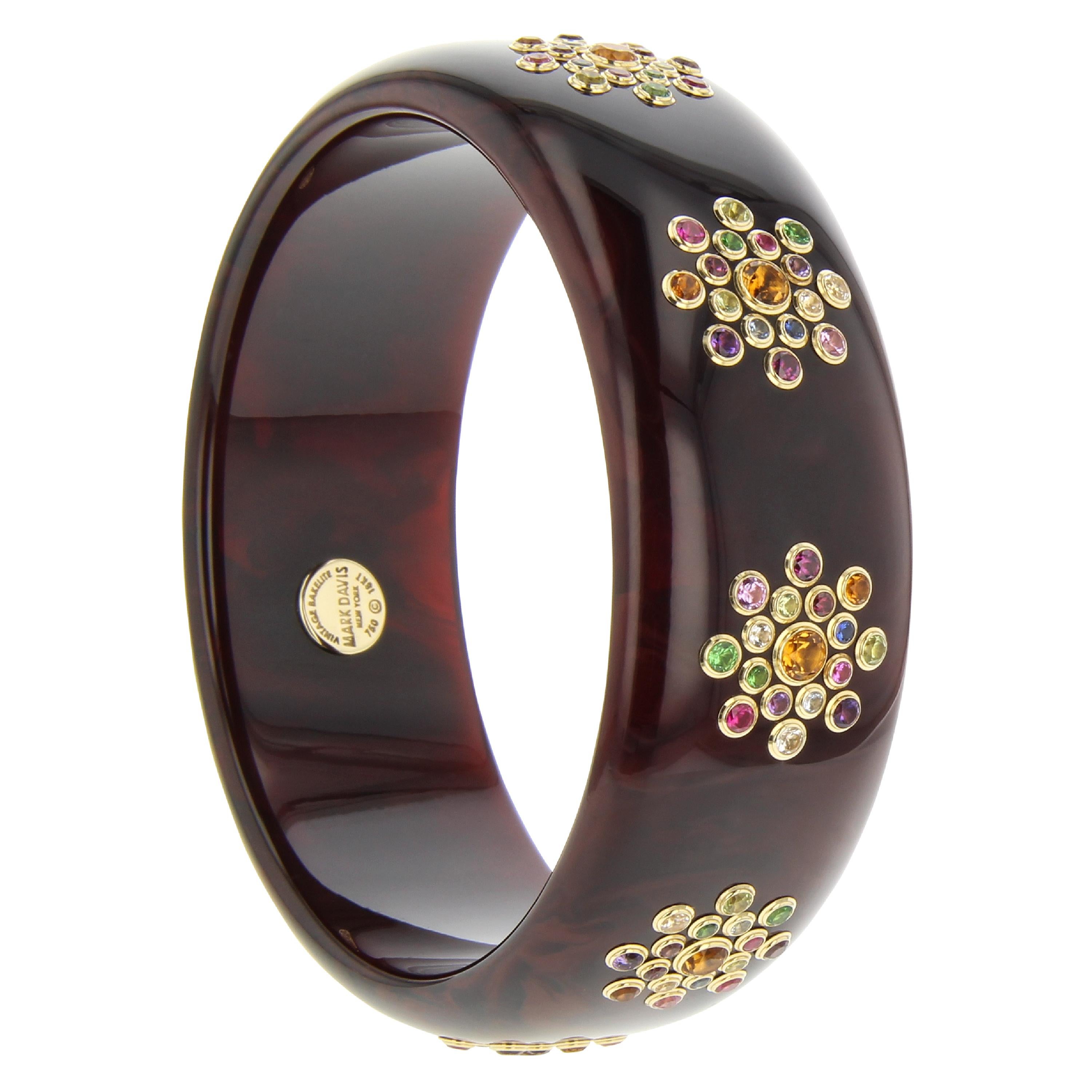 This elegant Mark Davis bangle was handcrafted using a rich, deep, marbled, brown, vintage bakelite set with a wide variety of fine gemstones in 18k yellow gold bezels.

Full details below:
• From the Mark Davis Bakelite line
• Vintage brown