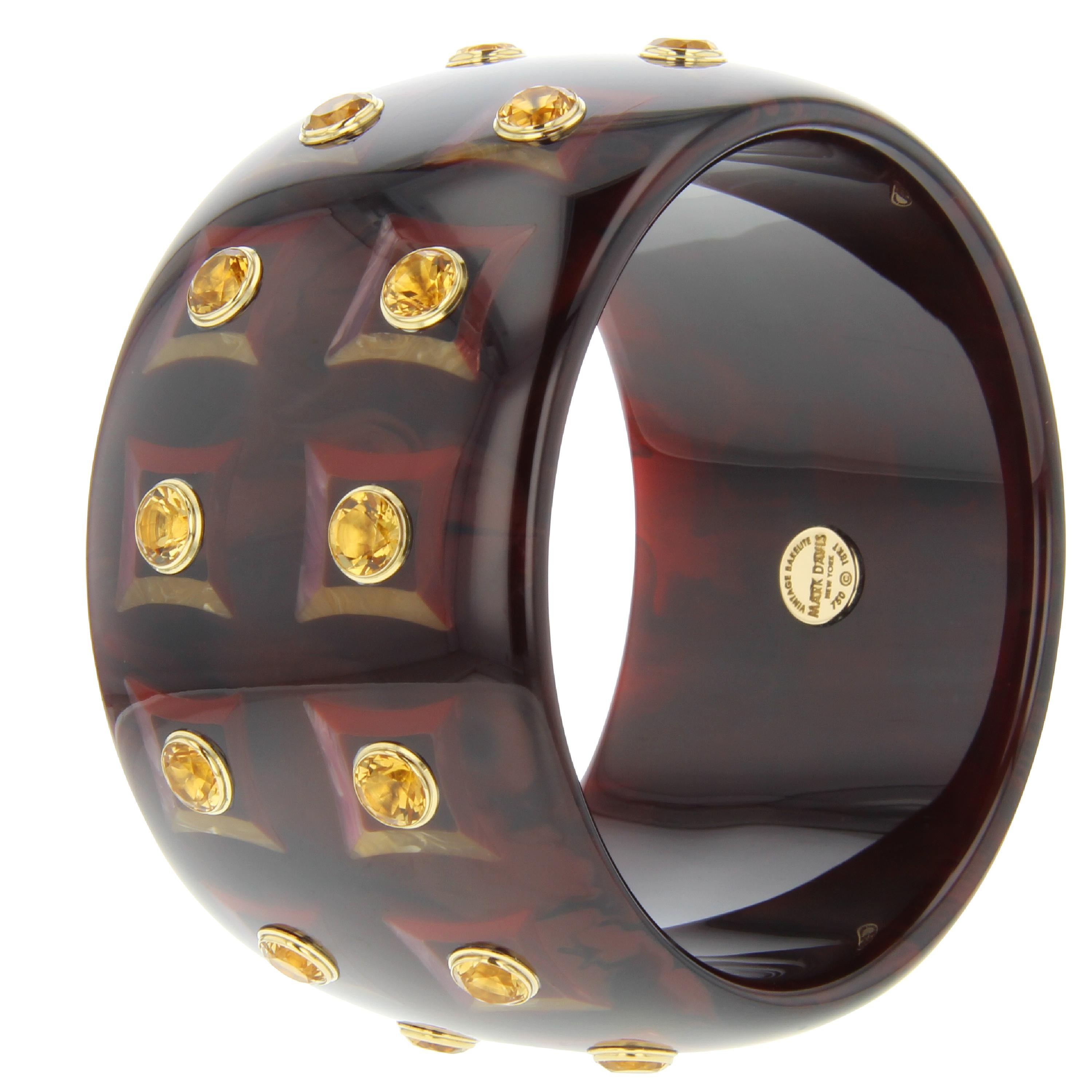 This stunning and substantial Mark Davis statement bangle was made using a very rich, deep, marbled brown vintage bakelite. An inlay pattern of slightly indented squares frames each bezel-set stone. The inlay pattern is comprised of burgundy,