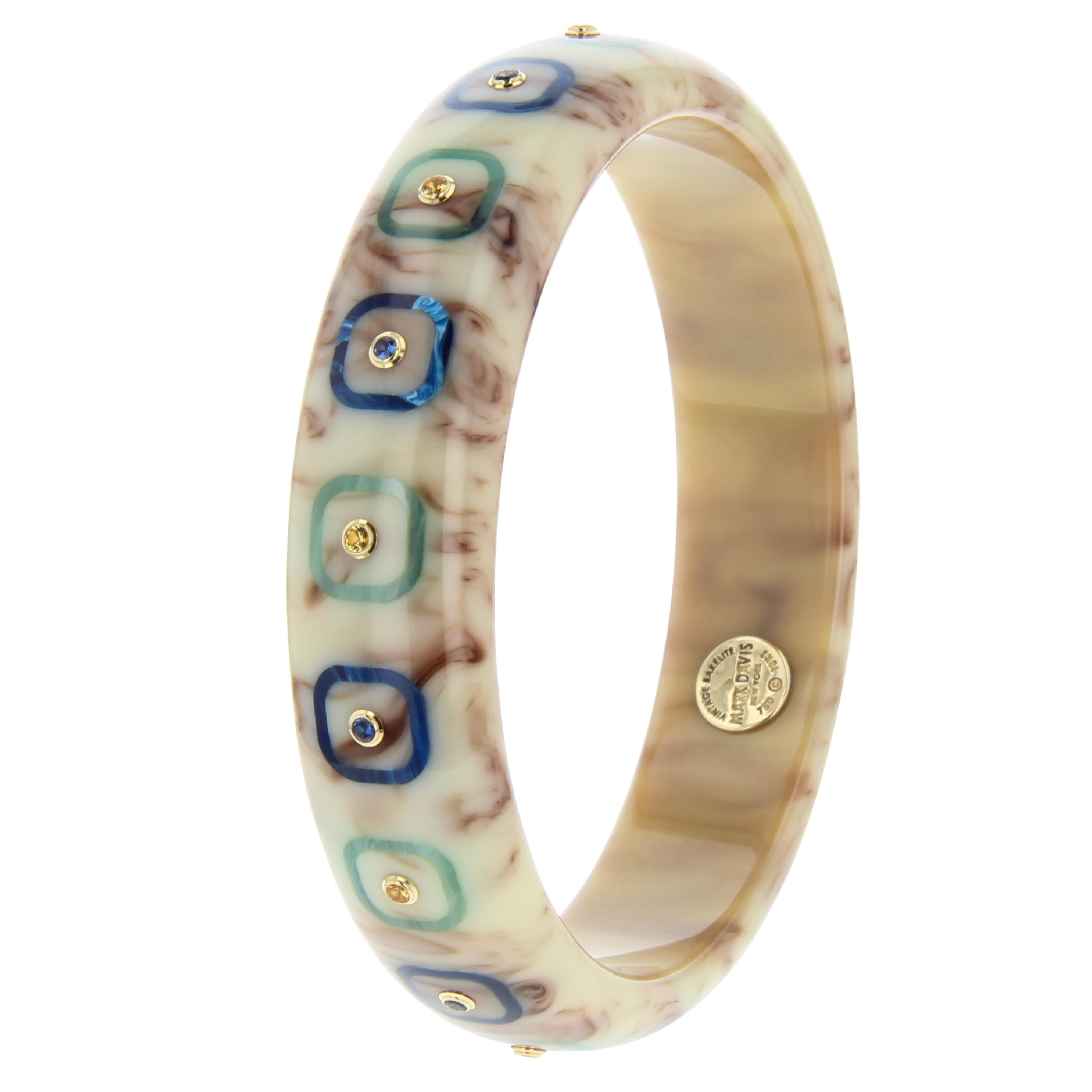This elegant and versatile Mark Davis bangle was created from vintage brown bakelite with bakelite inlay of alternating blue and green rounded square frames. The squares are centered by either blue or yellow sapphires set in individual 18k bezels.