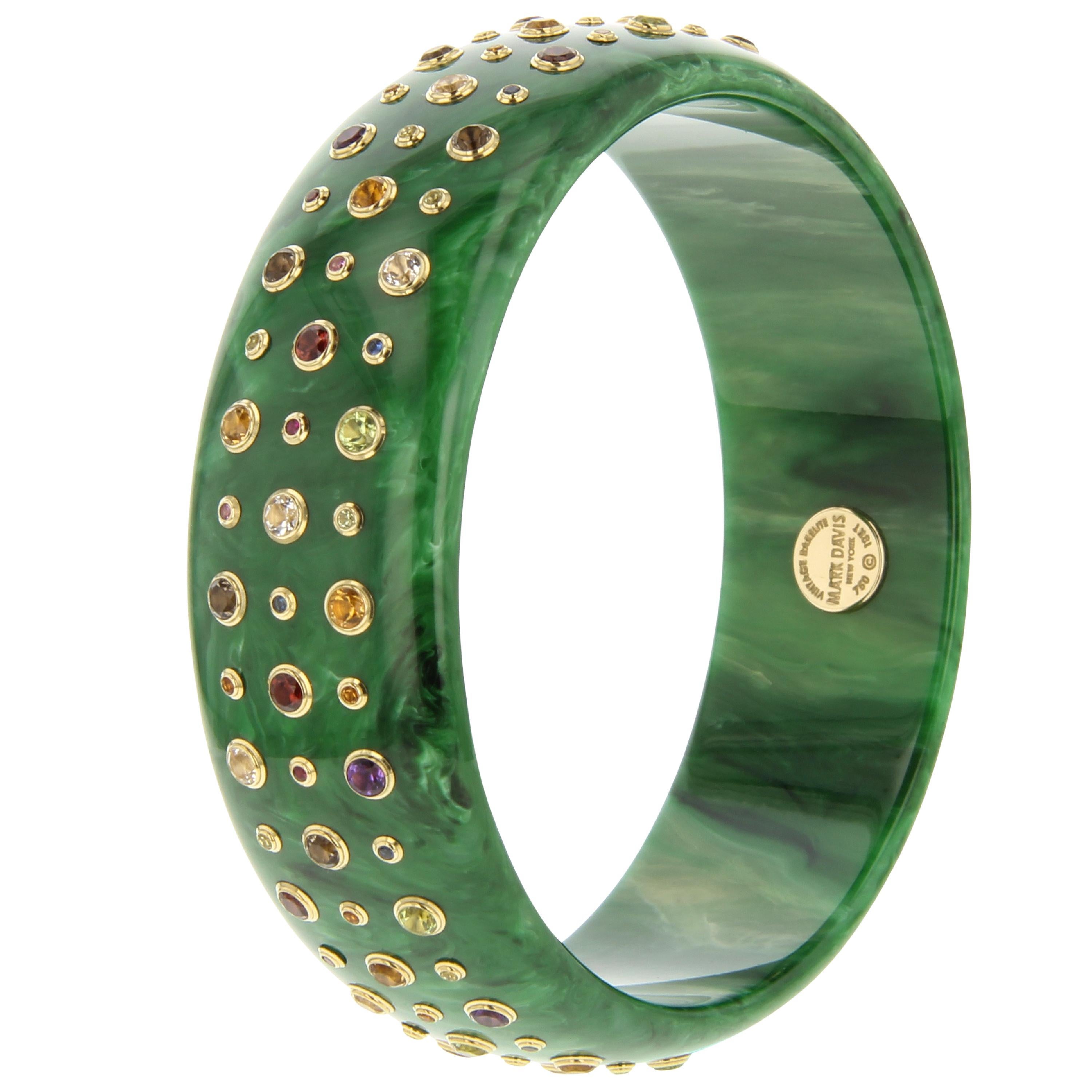 This Mark Davis bangle is simple but certainly not plain. A beautiful marbled green vintage bakelite bangle has been precisely set with with three rows of fine gemstones in alternating sizes. The bangle is simple, playful and a surprisingly