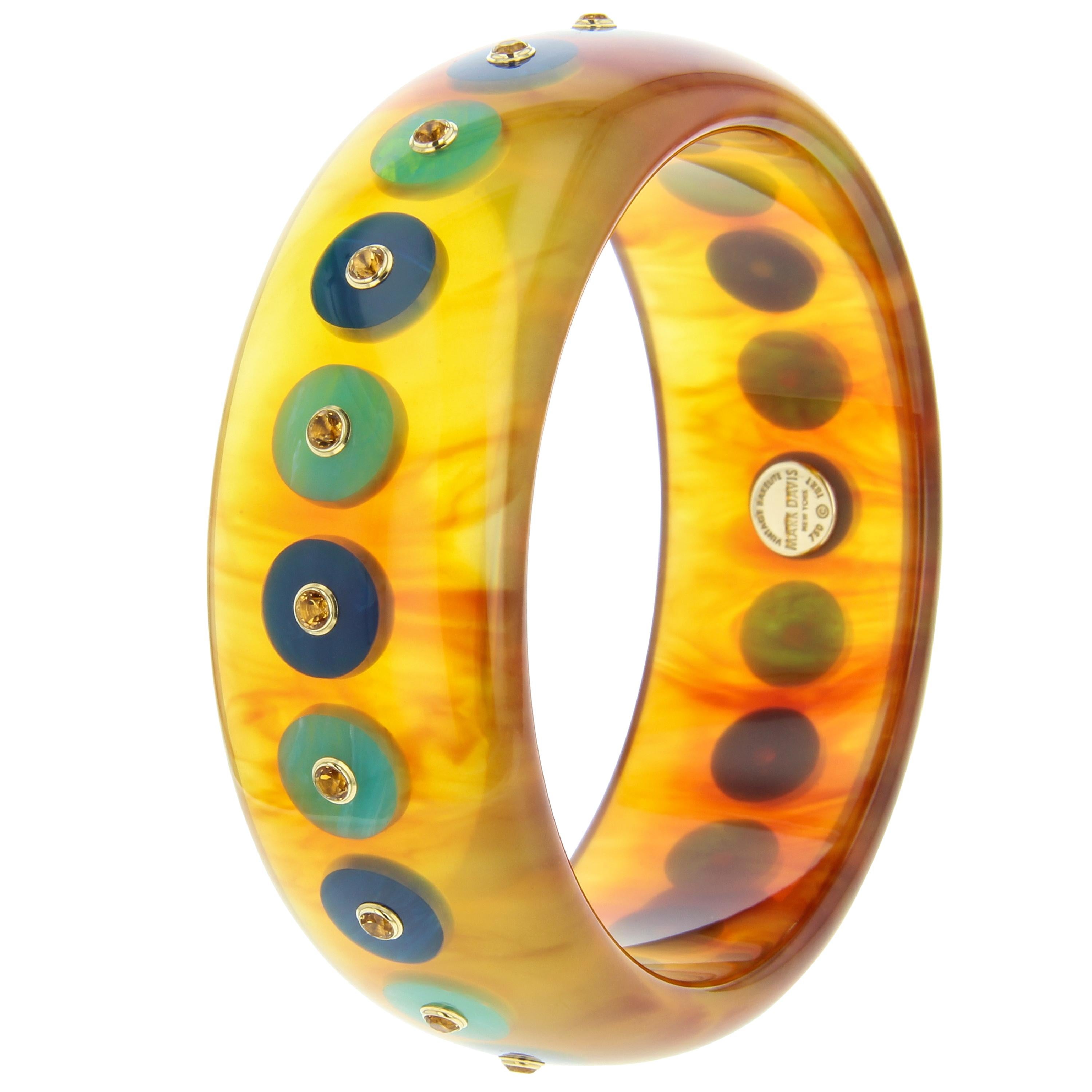 This striking Mark Davis bangle was handcrafted using a beautiful blonde tortoiseshell color vintage bakelite inlaid with blue bakelite polka dots centered with citrine set in individual 18k yellow gold bezels.

Full details below:
• From the Mark