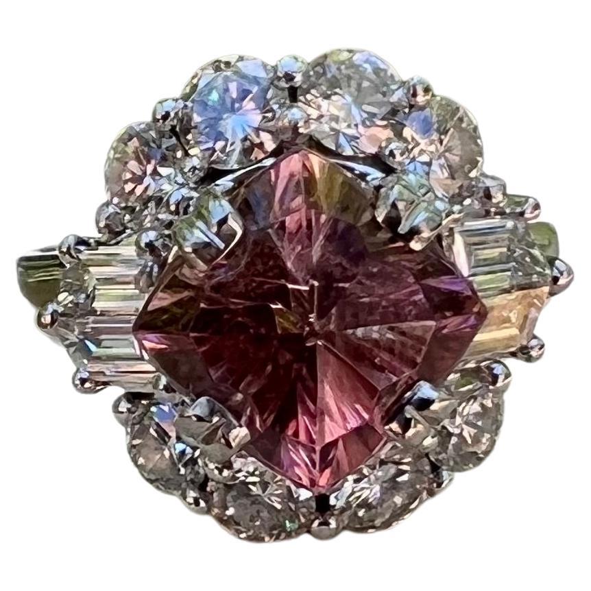 One 18 karat white gold (stamped 18K 750) ring set with one 3.63 carat starburst cushion pink tourmaline surrounded by eight round brilliant cut diamonds, approximately 1.30-carat total weight with matching G/H color and VS1 clarity and four