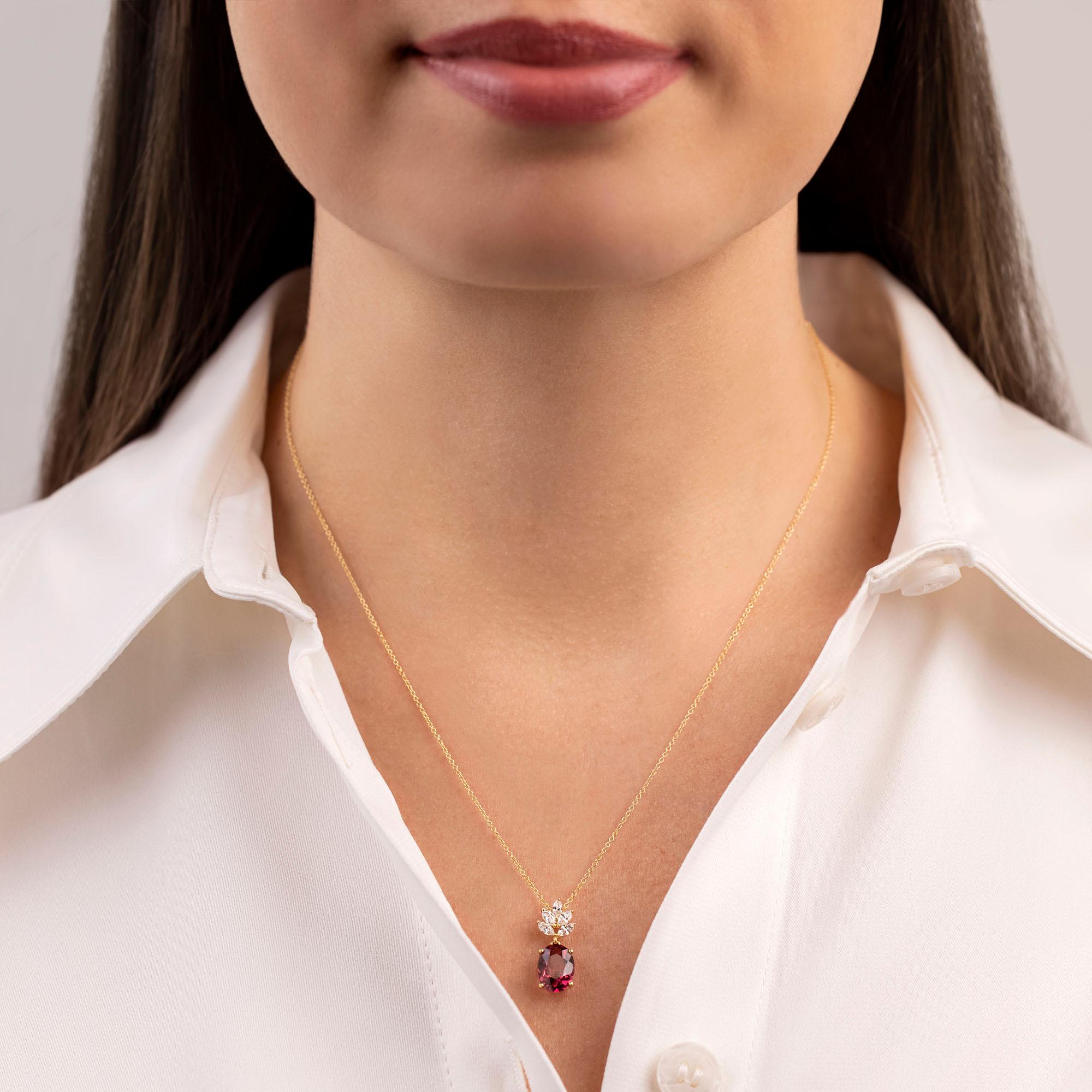 Our Olympia Pendant is set in a simple yet elegant design which highlights the rich pinkish red rubellite that dangles below an assortment of twinkling marquise shape diamonds. It is suspended from a delicate 18