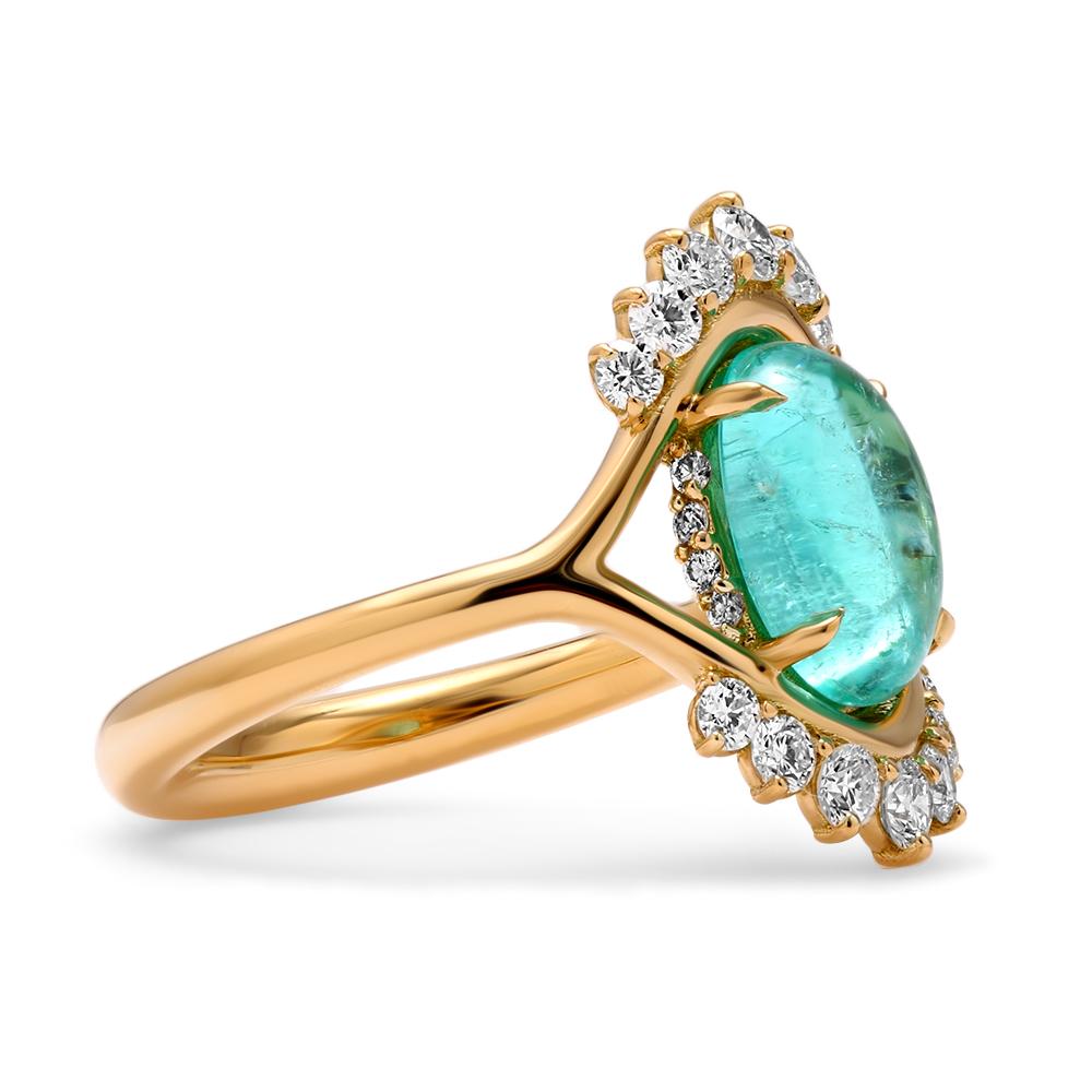 A slim split band elegantly curves around the smooth contours of the Paraiba tourmaline resting at the helm of the design to create a shape that is inspired by femininity. An assortment of twinkling diamonds of graduating sizes are set along the