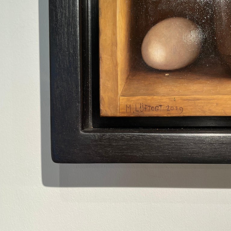 'Cake Mould with White Eggs' Realist painting with white eggs in a wooden cabinet by Mark Lijfogt. Amazing detail, sure to be the perfect addition to any kitchen, dinning room or living space. 

Lijftogt was born in Amsterdam and at the age of 19