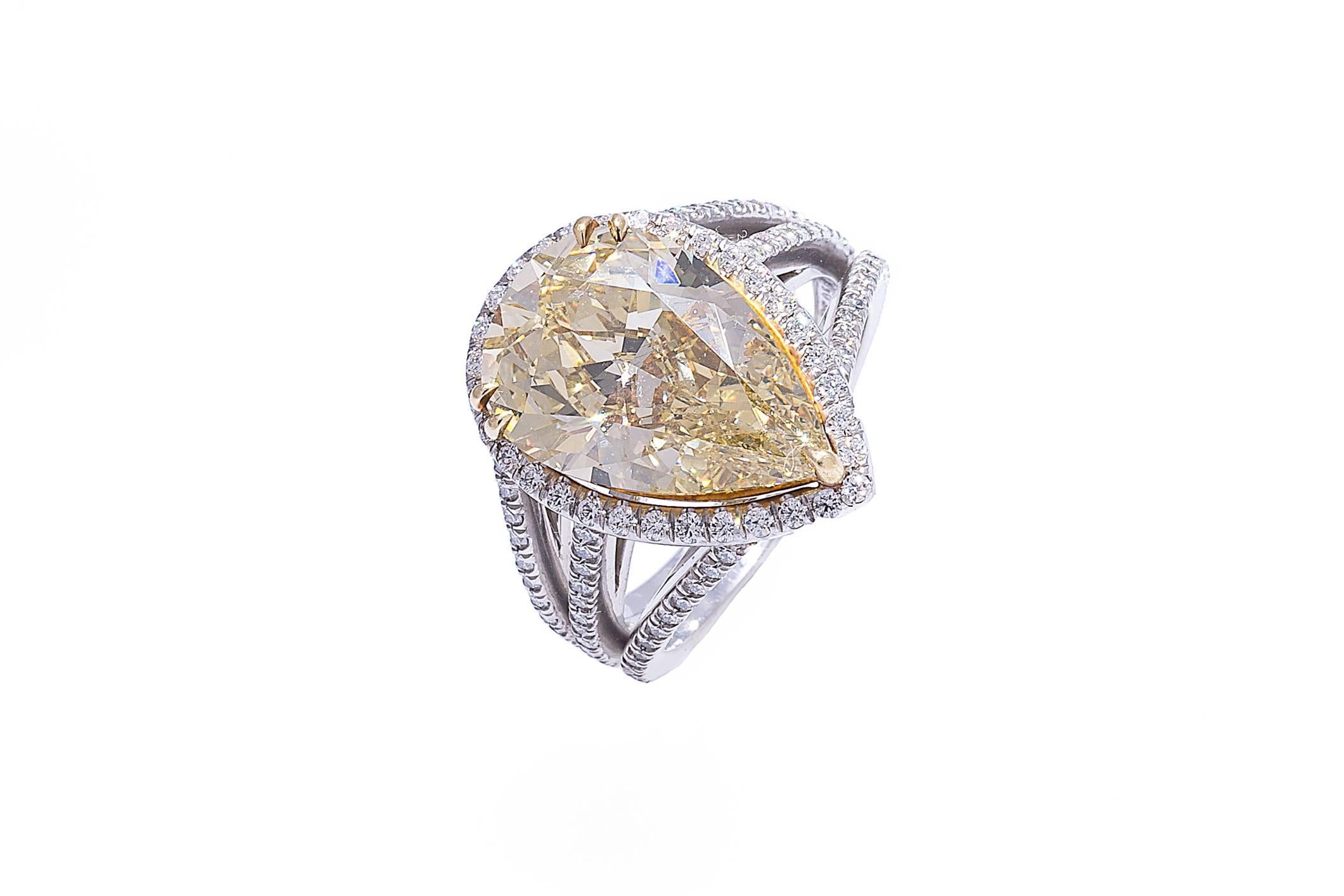 Platinum diamond ring containing a pear shape brilliant cut brownish yellow diamond weighing 5.62 carats. The pear shape diamond is set in 18K yellow prongs. The yellow diamond comes with a GIA Grading Report. The custom made platinum mounting