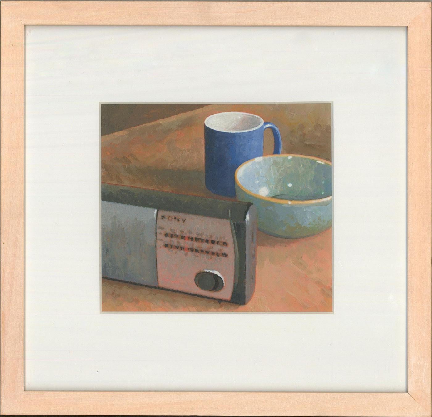 A crisp still life in acrylic in accomplished photo realistic style, showing a simple collection of objects; a radio, mug and pottery bowl. The painting has been presented in a pale oak frame with card mount. The artist has signed on a label to the