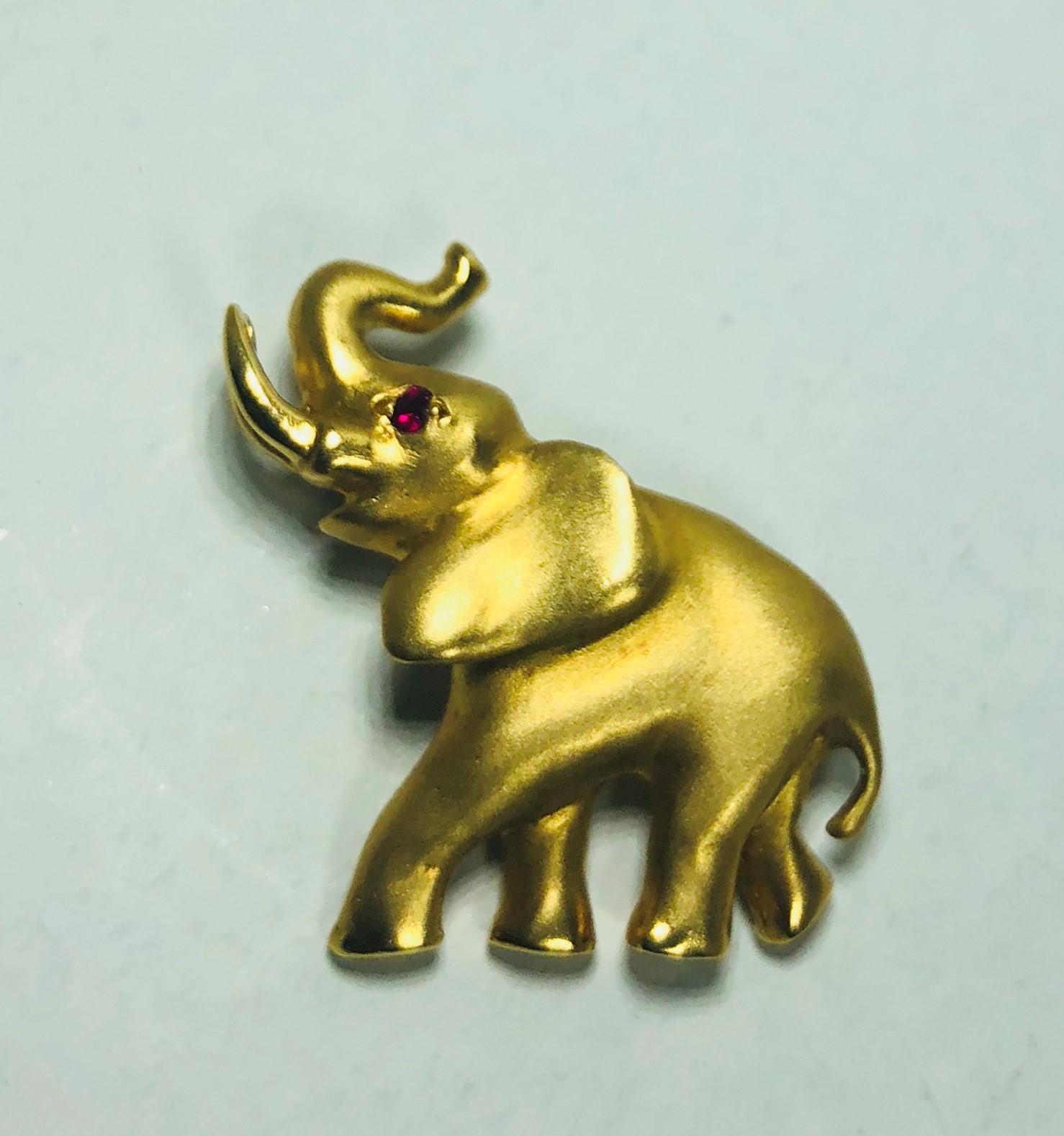 Mark Schneider 18 karat yellow gold and ruby elephant brooch. This is an authentic Mark Schneider original, created in 18 karat yellow gold, weight= 4.9 dwt, 7.7 grams. This brooch/pin has a 1.6mm round ruby 