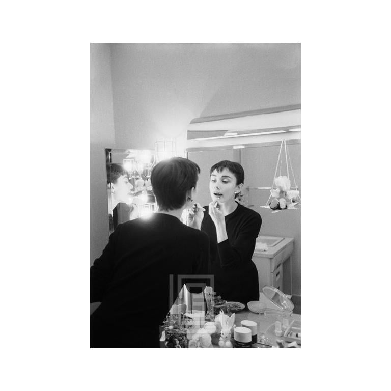 Mark Shaw Black and White Photograph - Audrey Hepburn Applies Lipstick in Mirror, Backstage at Ondine, 1954