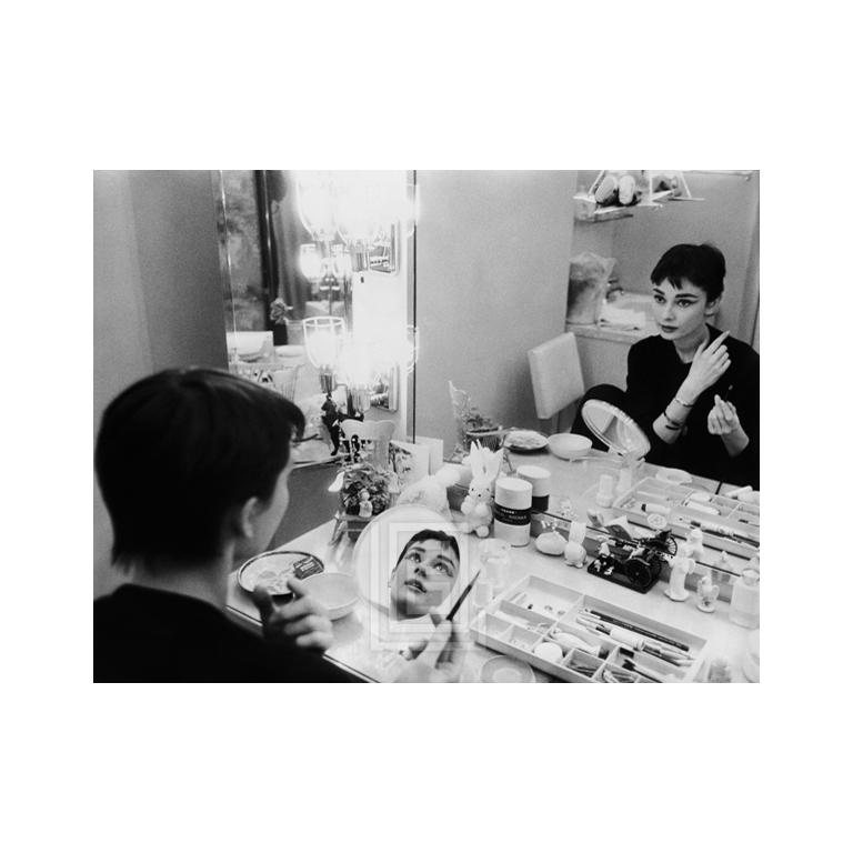 Mark Shaw Portrait Photograph - Audrey Hepburn Applies Makeup in Two Mirrors, Backstage at Ondine, 1954