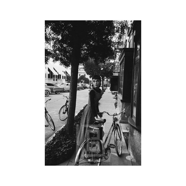 Mark Shaw Black and White Photograph - Audrey Hepburn Bicycle, Looks Left, 1953