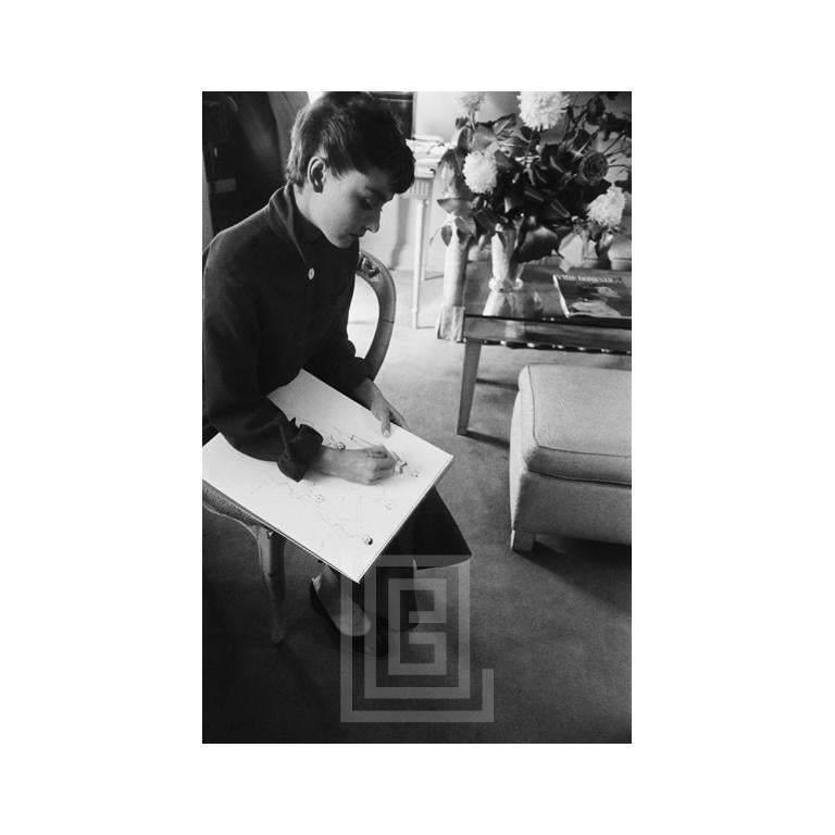Figurative Photograph de Mark Shaw - Audrey Hepburn consulta con el vestuarista, 1953